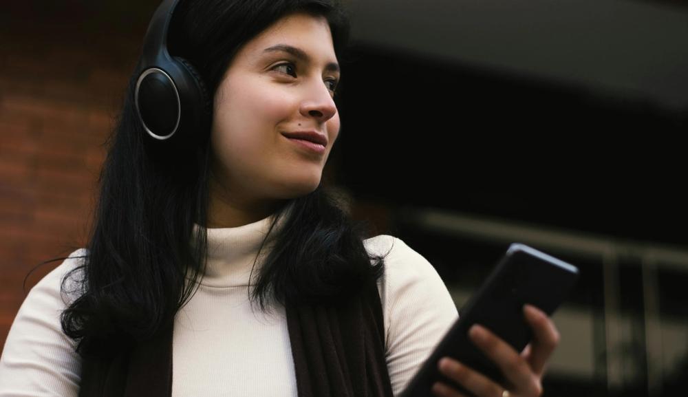 Ung kvinne som lytter til musikk i hodetelefoner