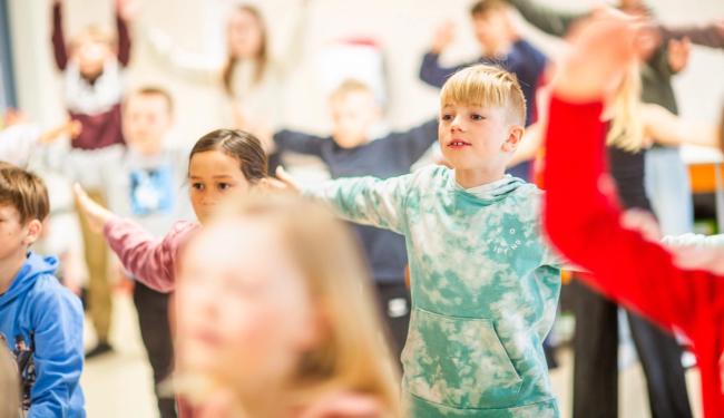 Elever synger og danser i klasserommet