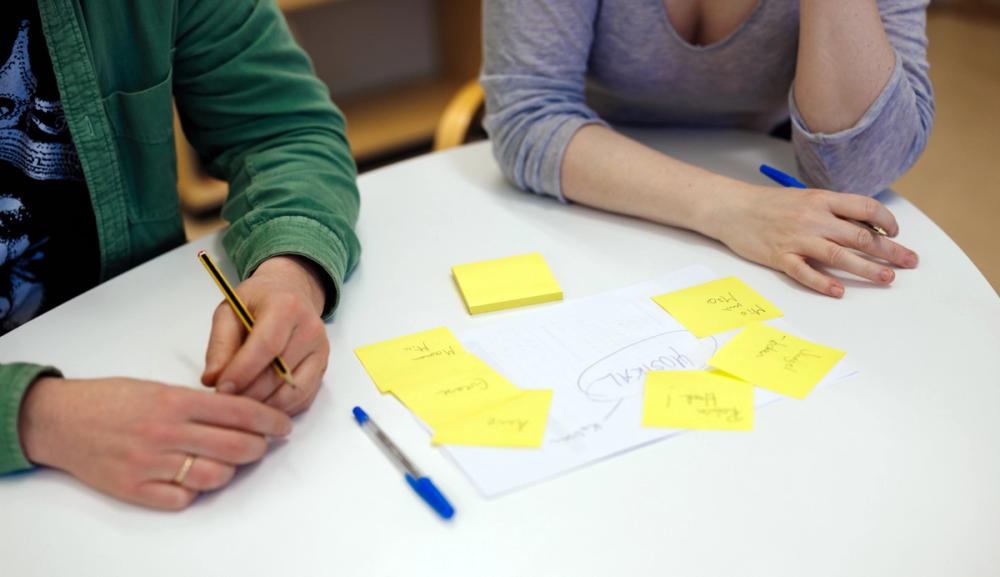 Lærere jobber rundt et bord med notater og gule lapper