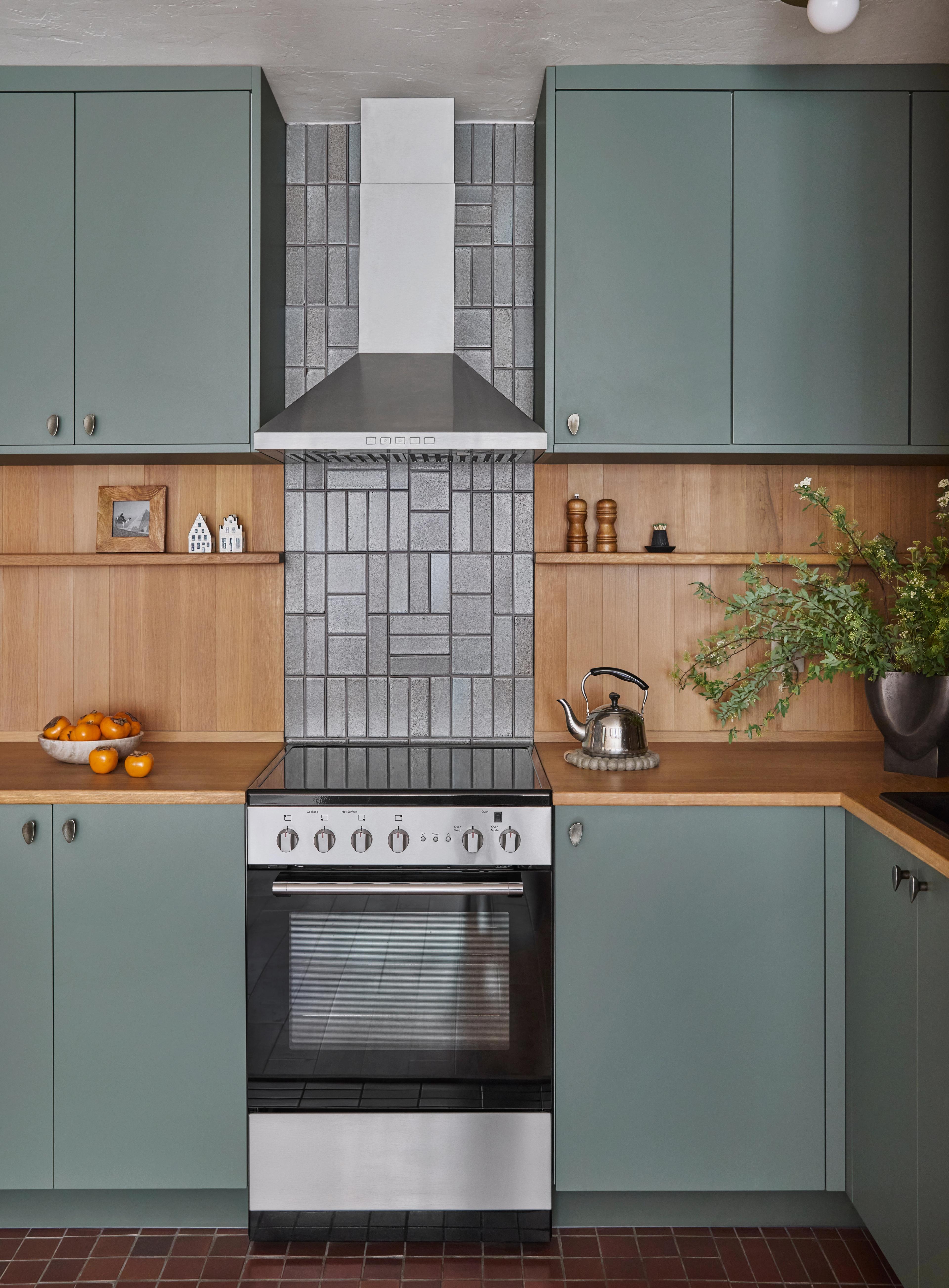 Kitchen with sage green cabinets, white oak surround, and patterned tile backsplash, designed by Studio VAE.