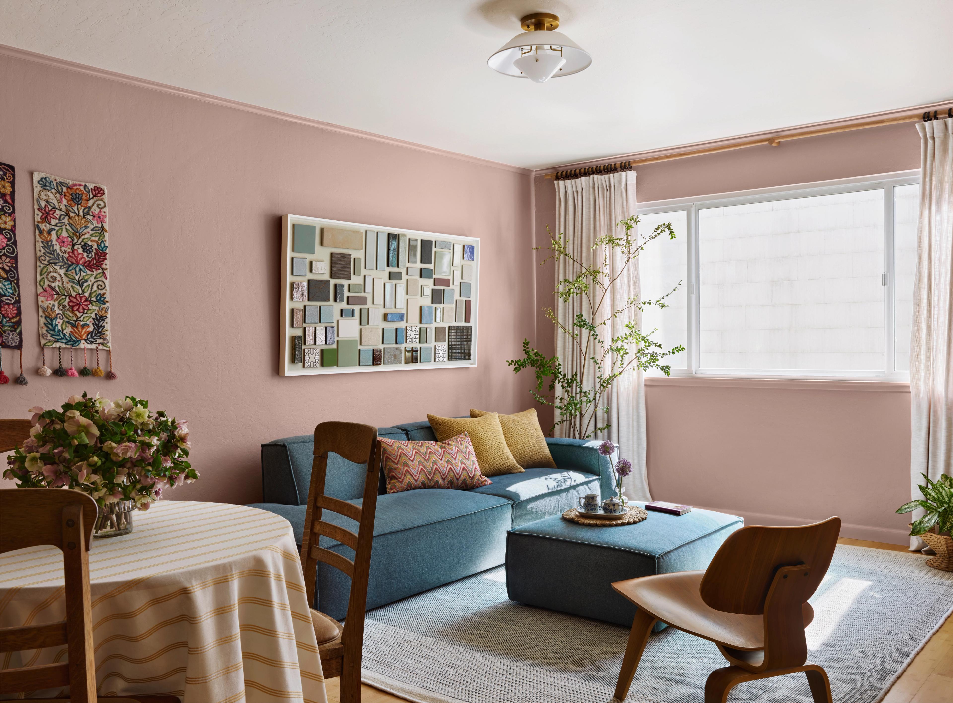 Living room with dusty pink walls, blue sofa and framed tile sample art in Outer Sunset home designed by Studio VAE, San Francisco interior designer