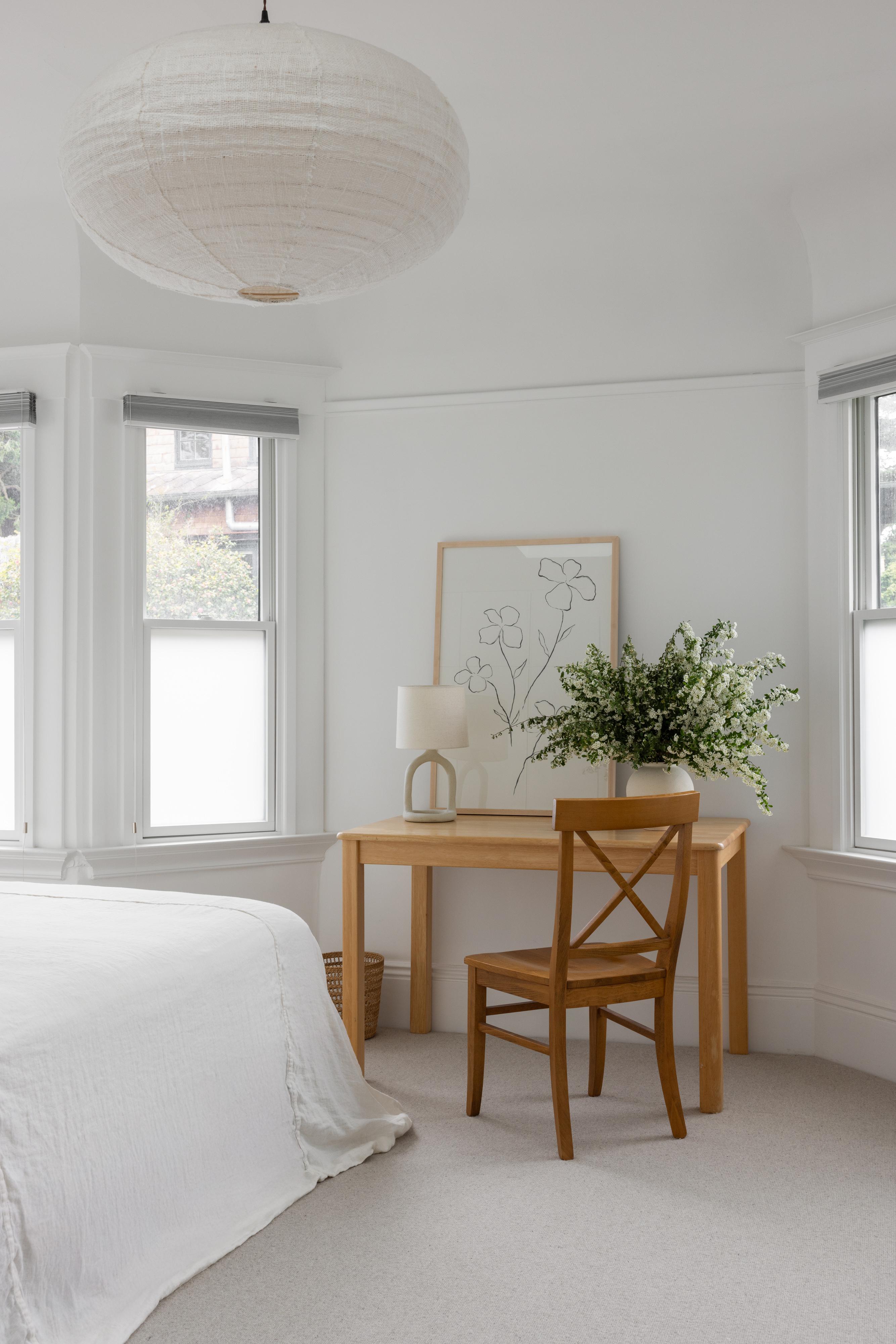 Primary bedroom with desk near windows, and paper pendant lamp in Parnassus Heights home designed by Studio VAE.