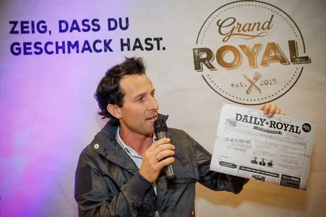 Grand Royal Event Moderator mit Zeitung