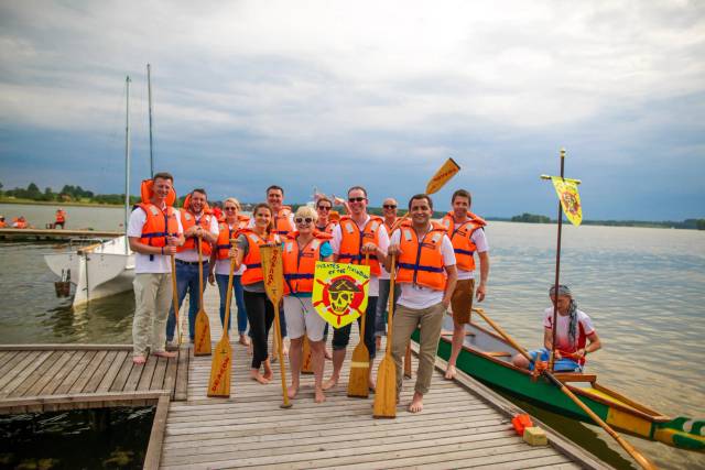 Drachenboot-Team am Steg mit Rudern