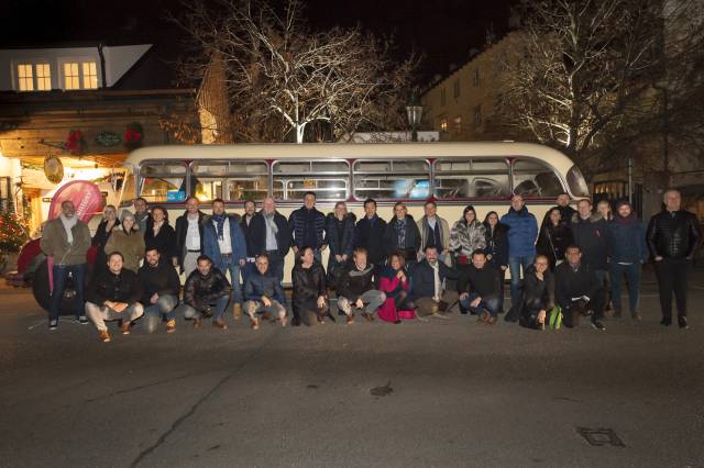 Gruppe vor Oldtimer-Bus bei Nacht