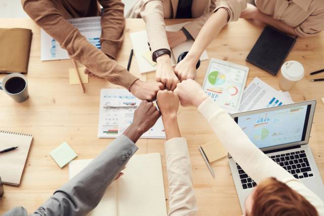 Team Fist Bump Over Strategy Charts