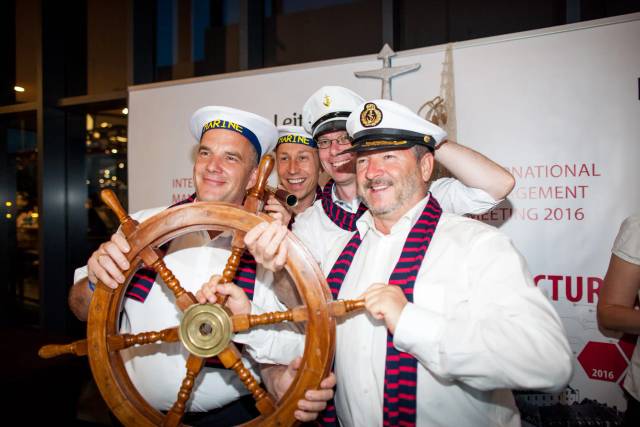 Männer in Matrosenuniform am Steuerrad