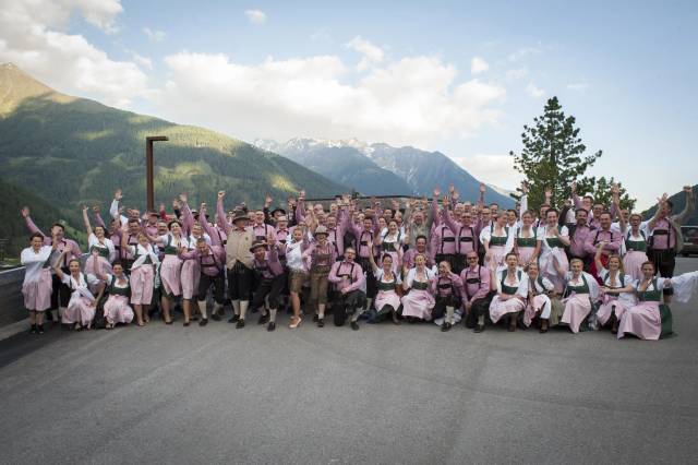 Gruppe in Tracht vor Alpenpanorama