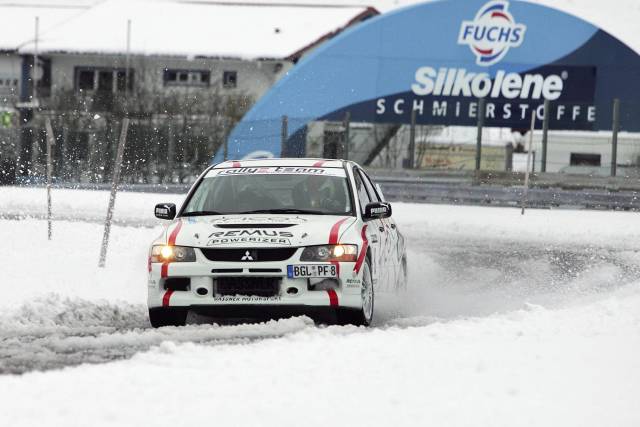 Rallyeauto driftet durch verschneite Piste