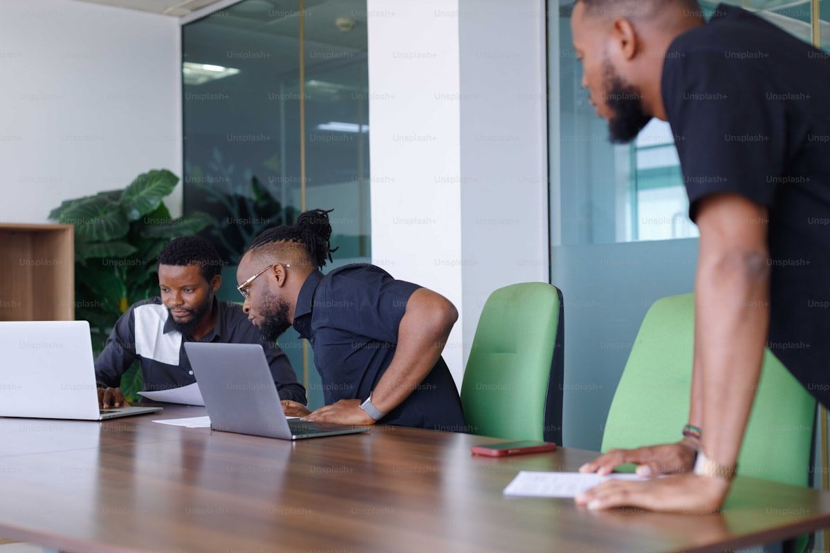 African tech professionals reviewing code together on a laptop at a collaborative workspace