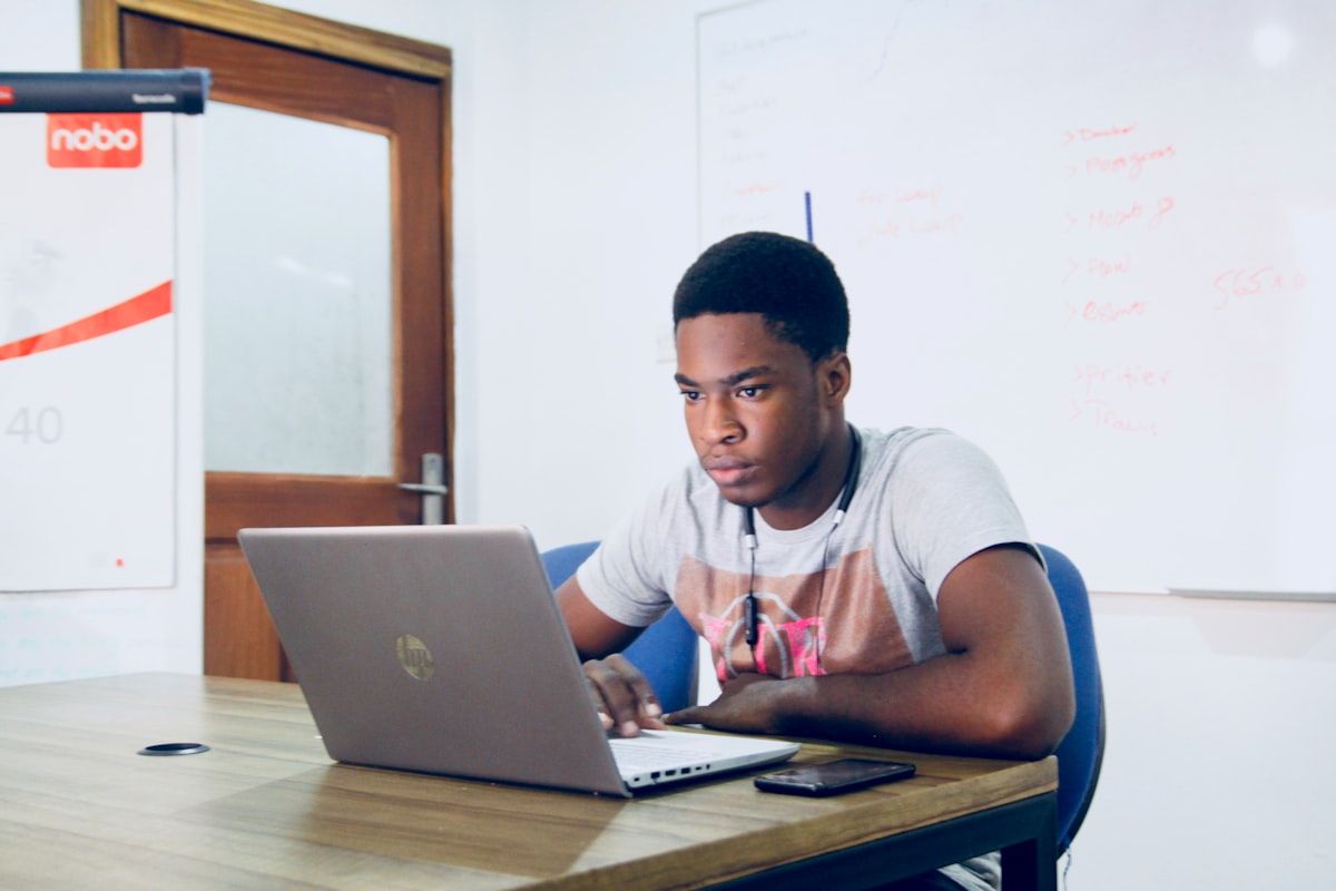 Developer working on a laptop at a shared workspace focused on coding