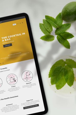 Hero image featuring a Mojito cocktail and an ipad with the Blue Flamingo website.