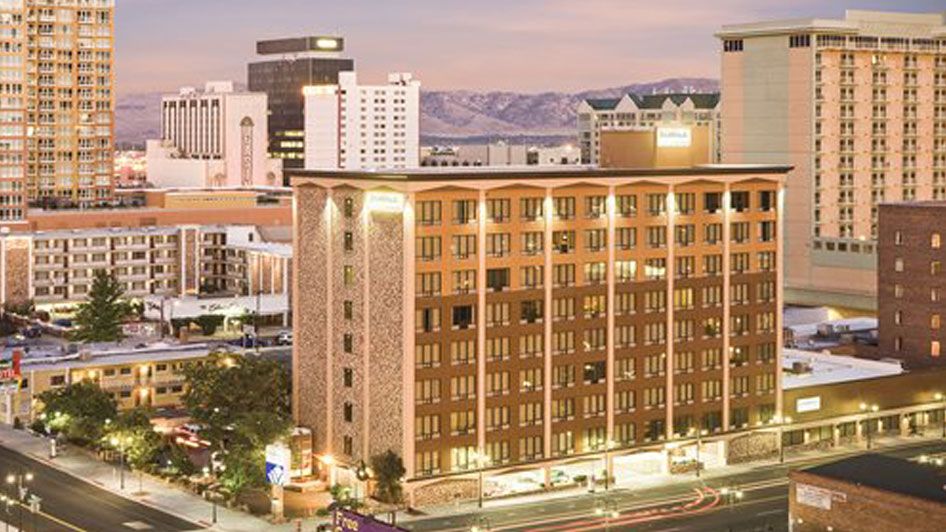 A large hotel building with a mountain view