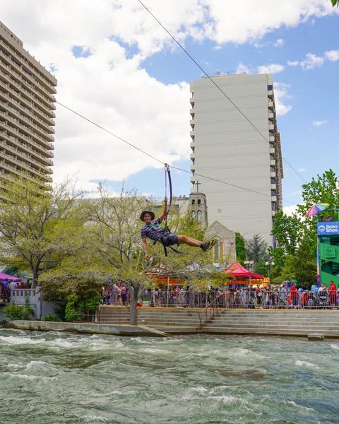 Man zip lining across the Truckee River at Reno River Festival