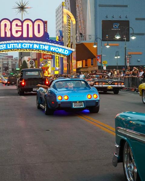 Cars driving in a parade under the Reno arch at Hot August Nights.