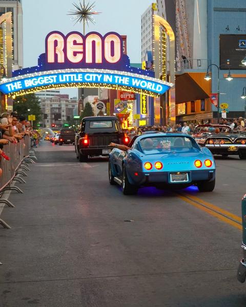 Cars driving in a parade under the Reno arch at Hot August Nights.