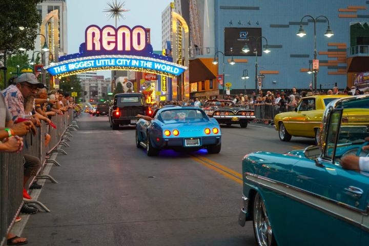 Cars driving in a parade under the Reno arch at Hot August Nights.