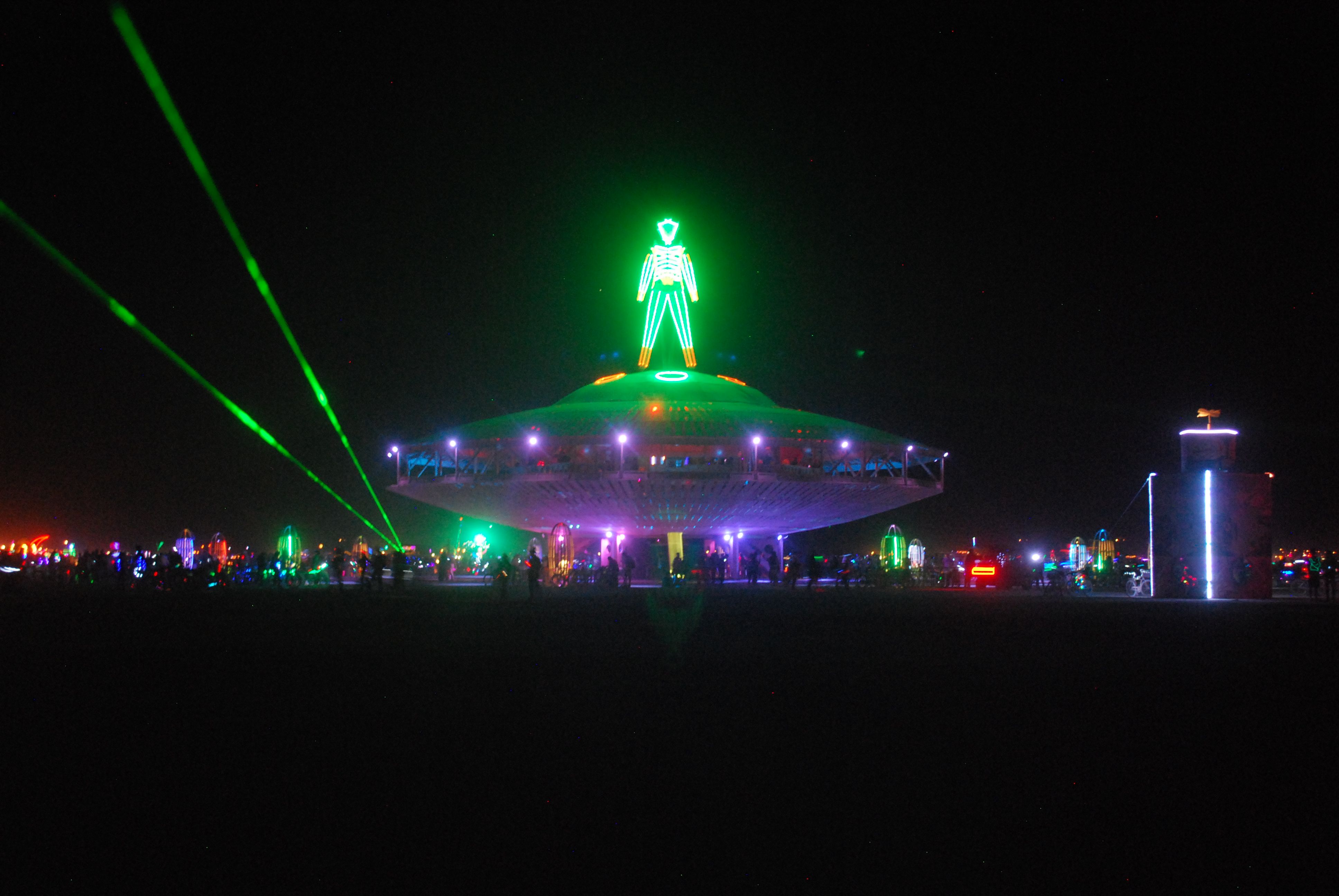 Neon man on top of spaceship structure at Burning Man