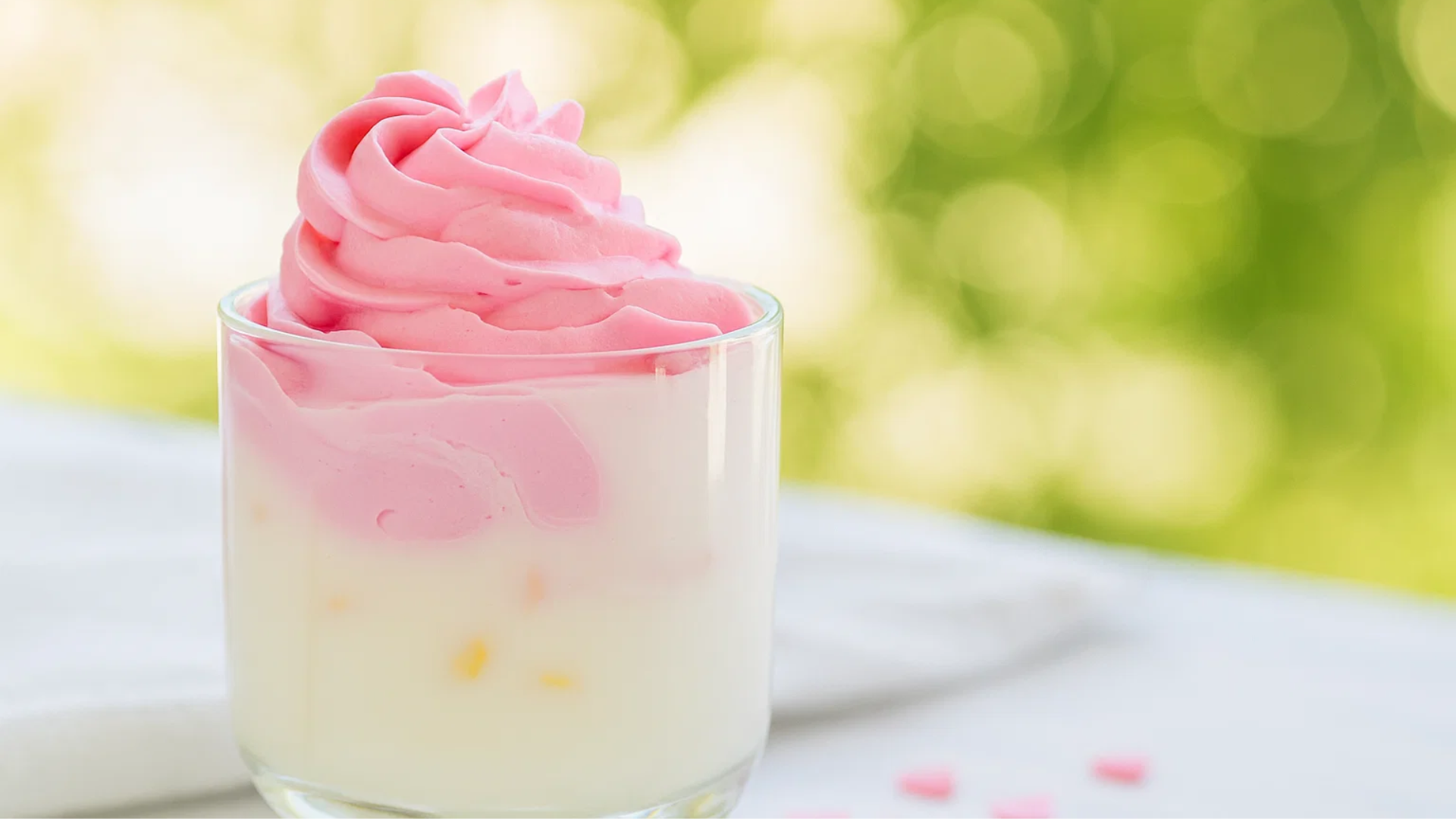Image of a glass filled with a drink topped with a pink swirl