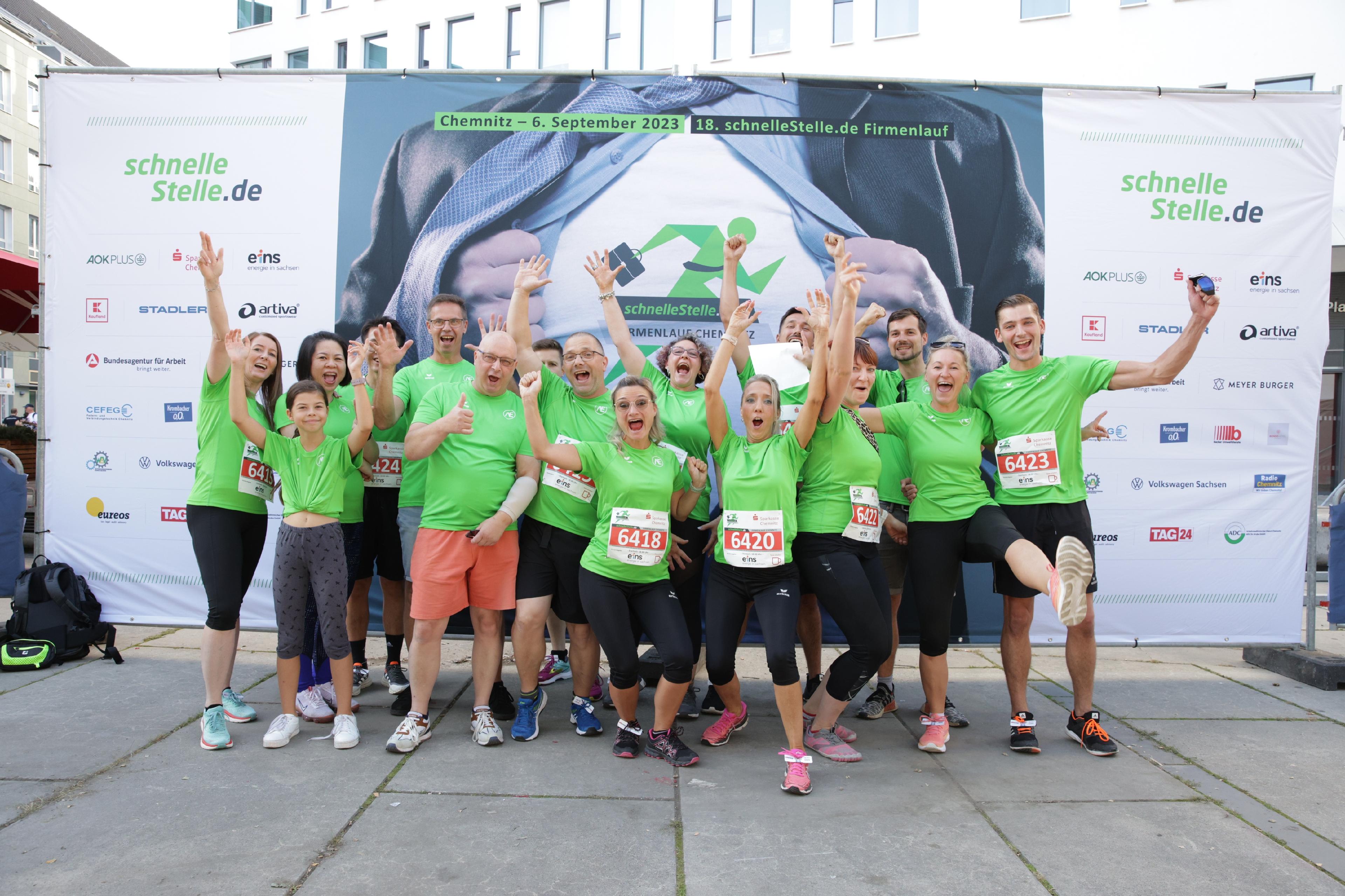 Eine Gruppe von Menschen posiert vor einem großen Banner