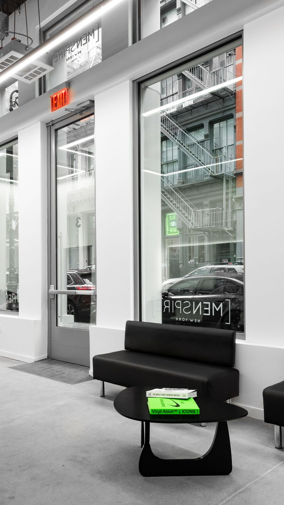 The entrance and front windows of MENSPIRE New York, with a sofa and low table inside
