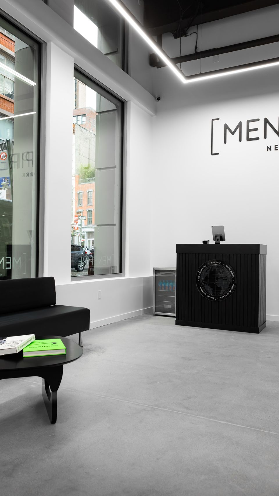 The front desk and waiting area at MENSPIRE New York, with the MENSPIRE New York logo on the wall