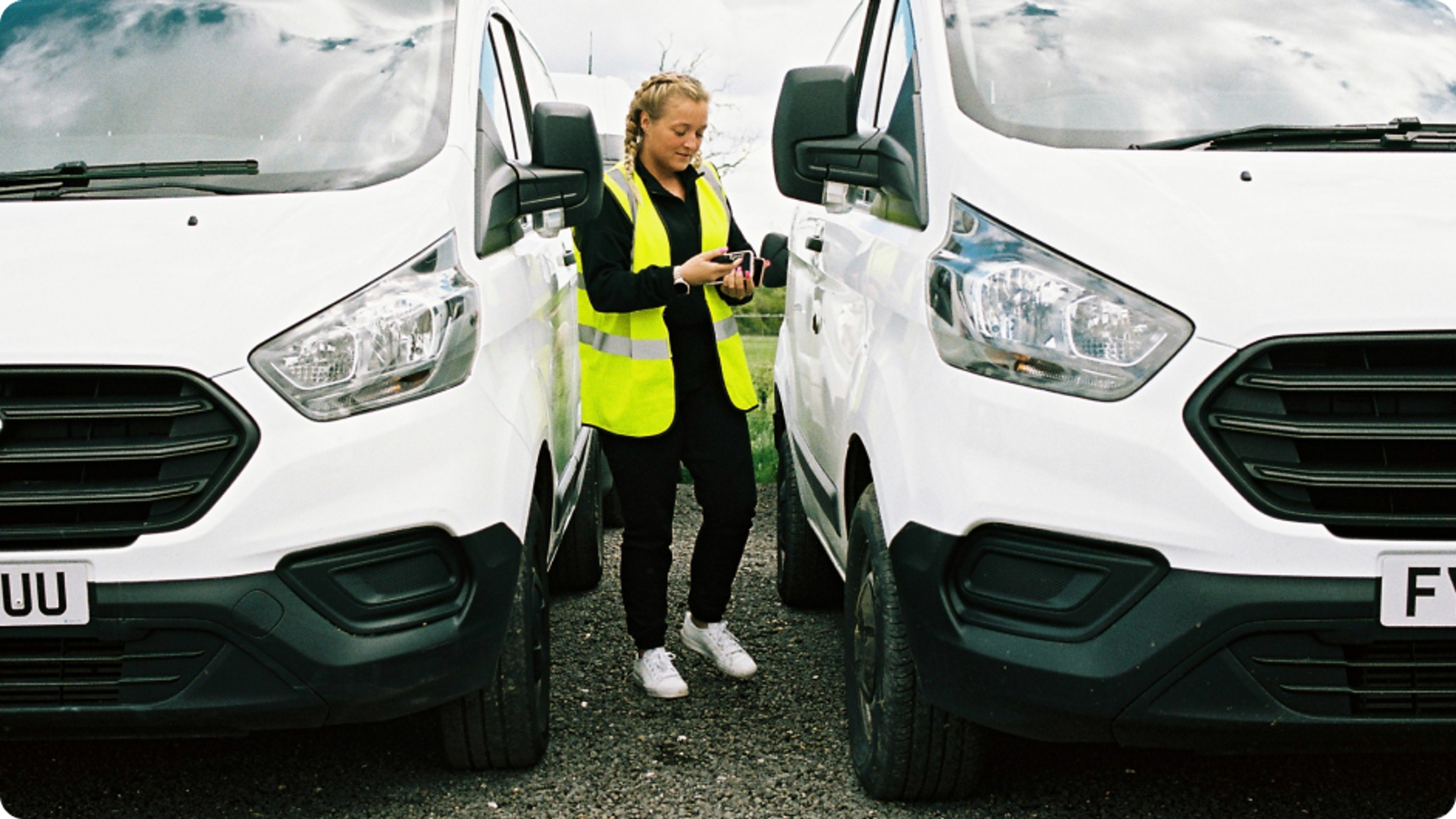 female business van driver checking her insurance quote next to a van
