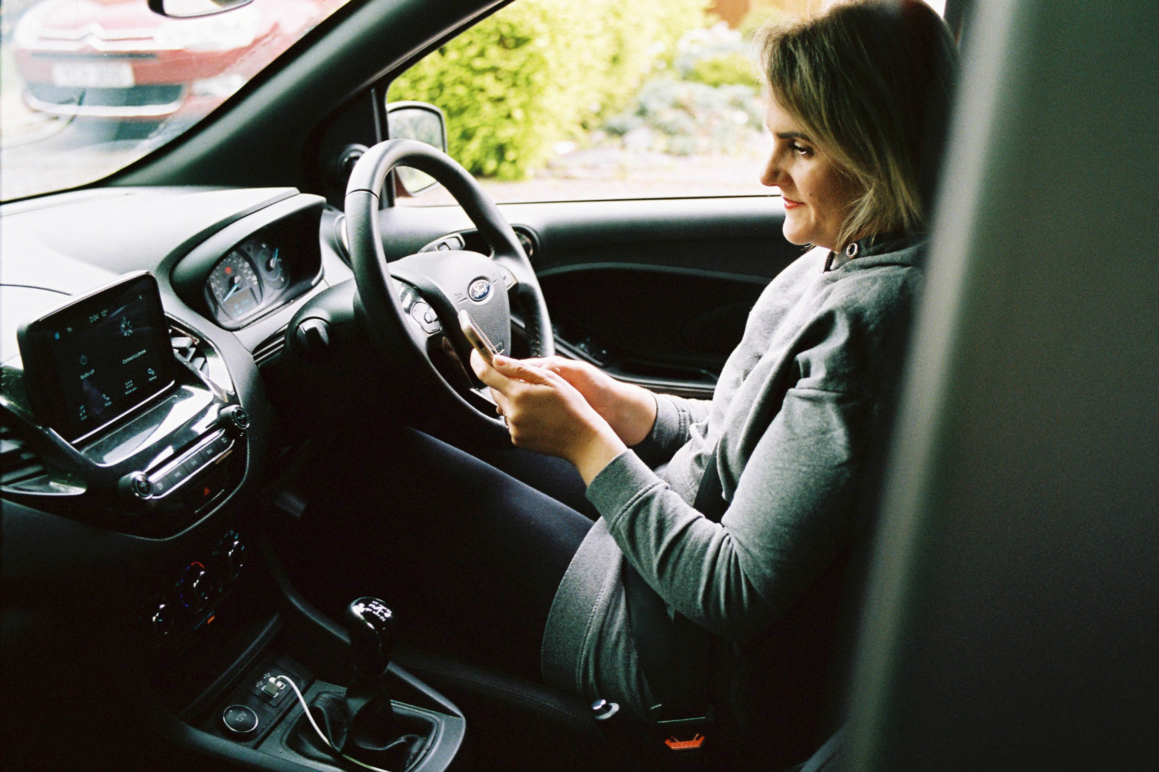 Driver looking at smartphone while parked up