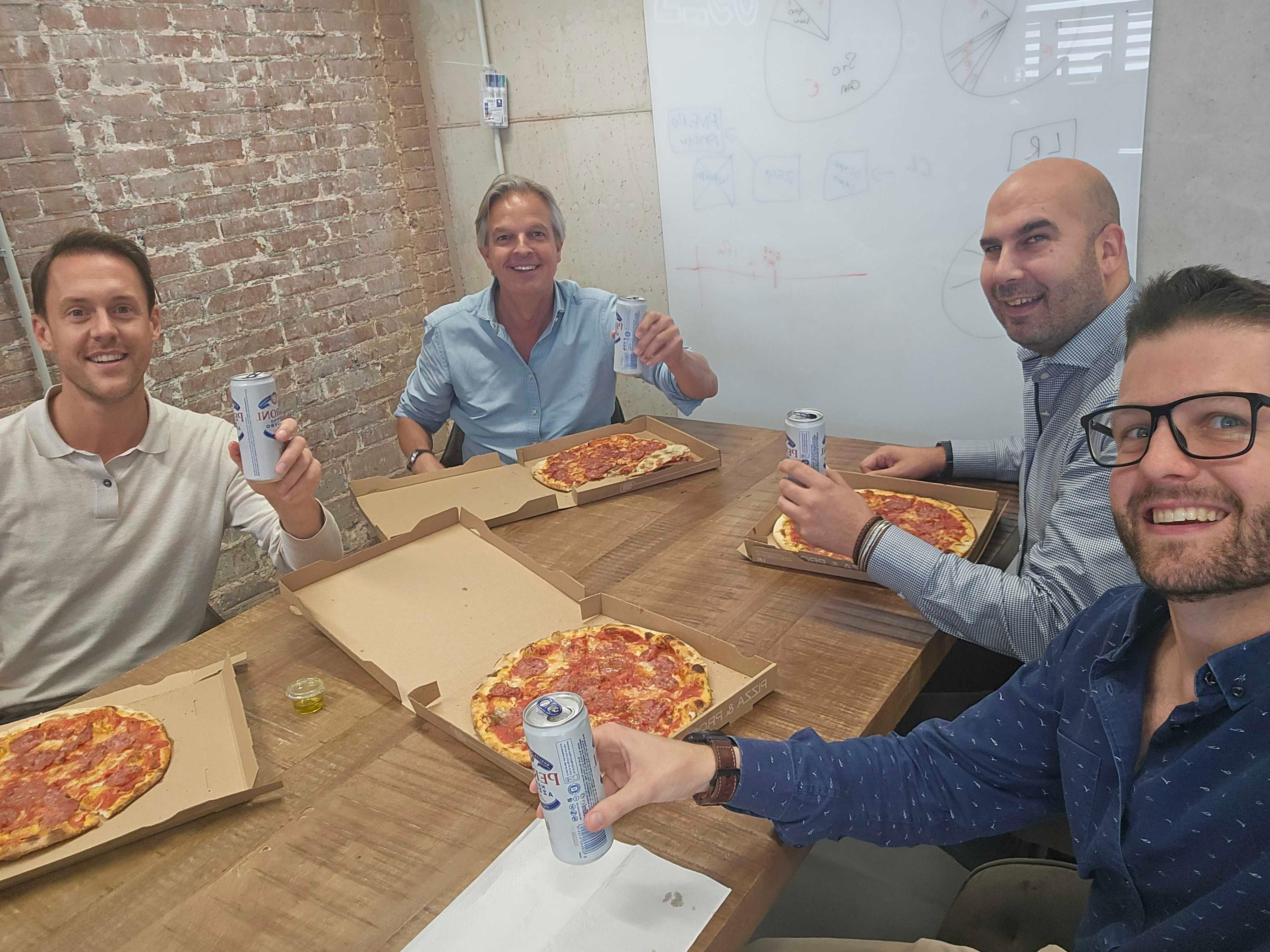 Colleagues eating pizza in a meeting room