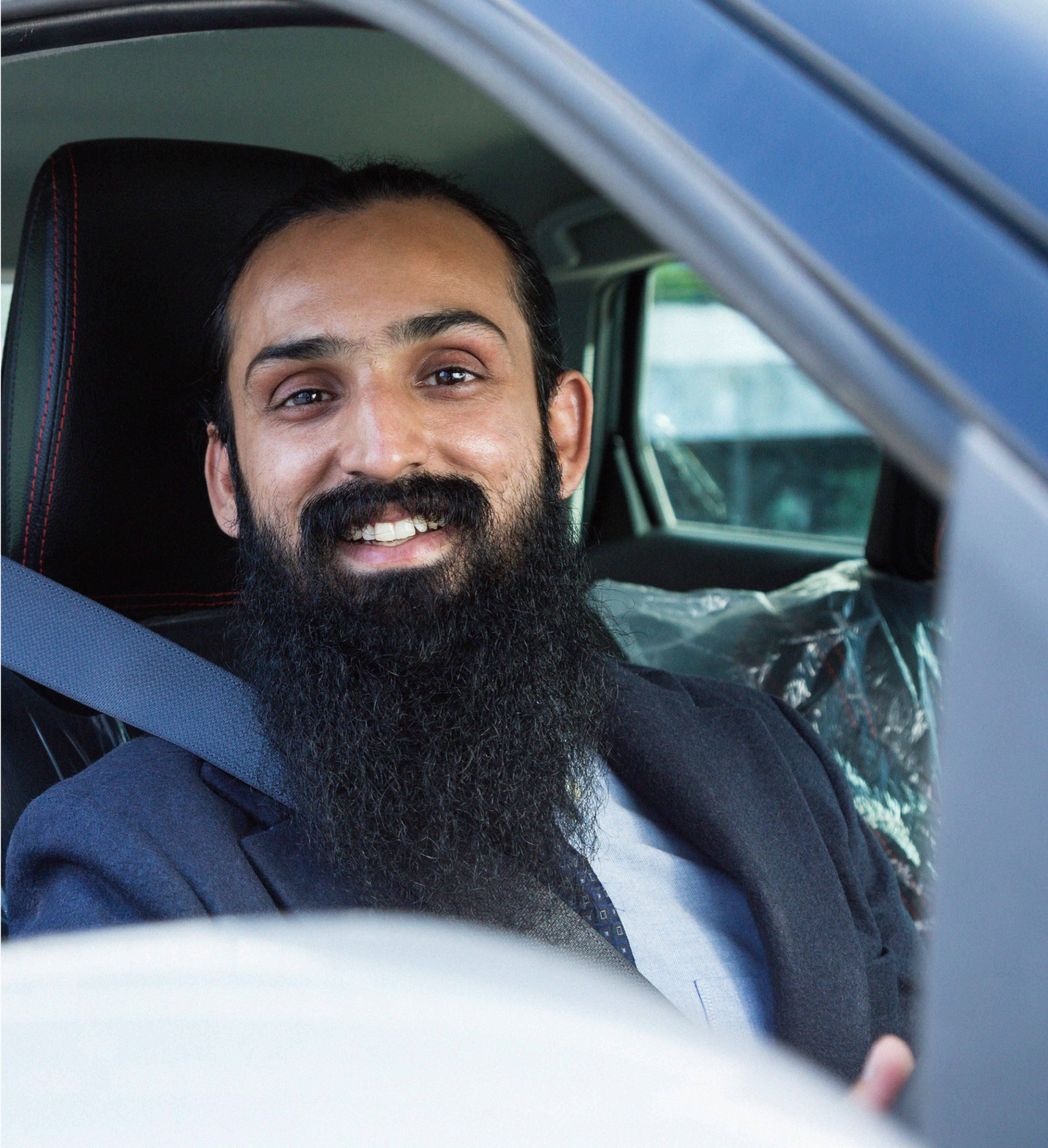 Smiling Zego private hire taxi driver sat in his car