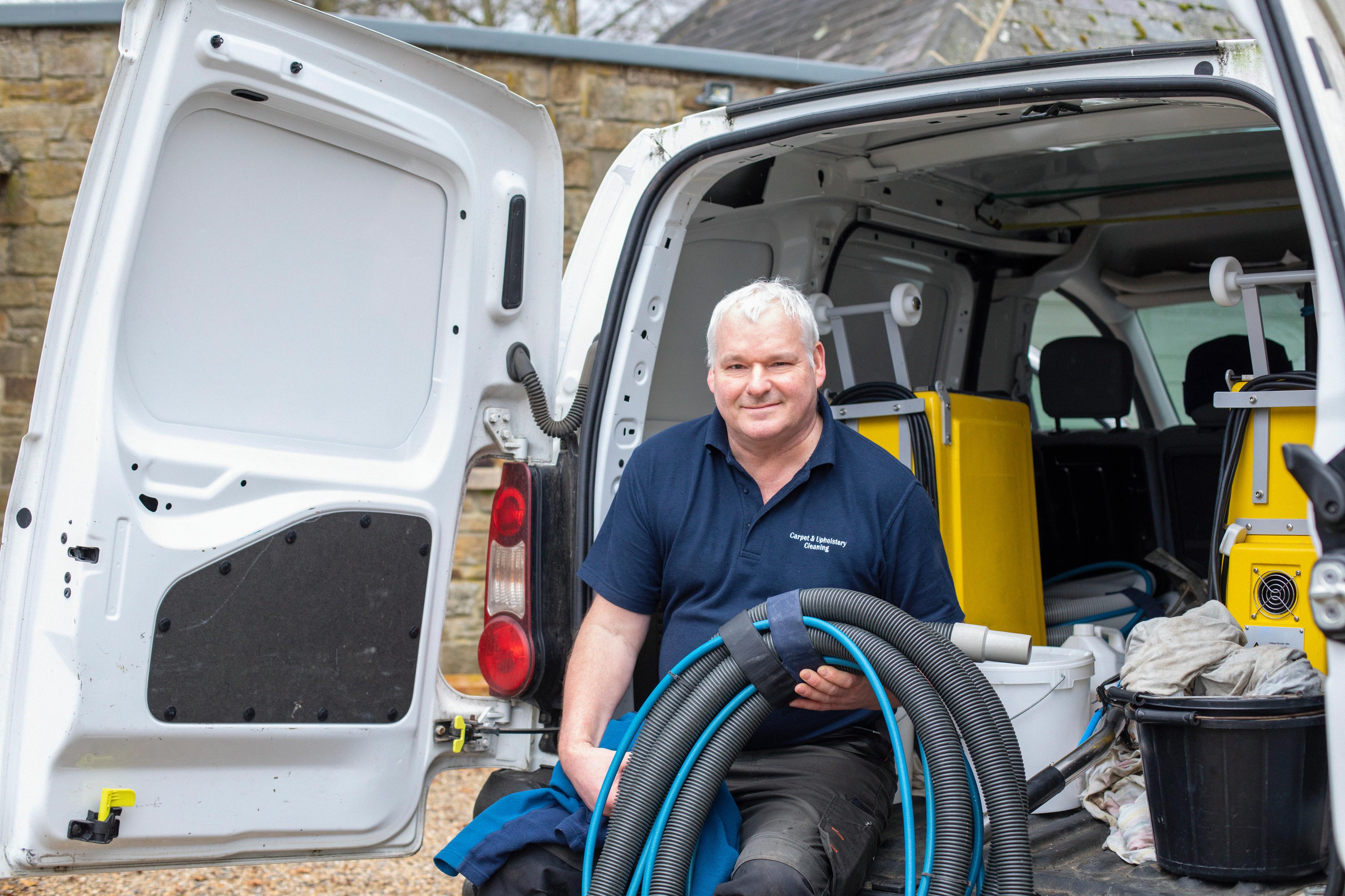 Van driver with tools sitting inside of parked van