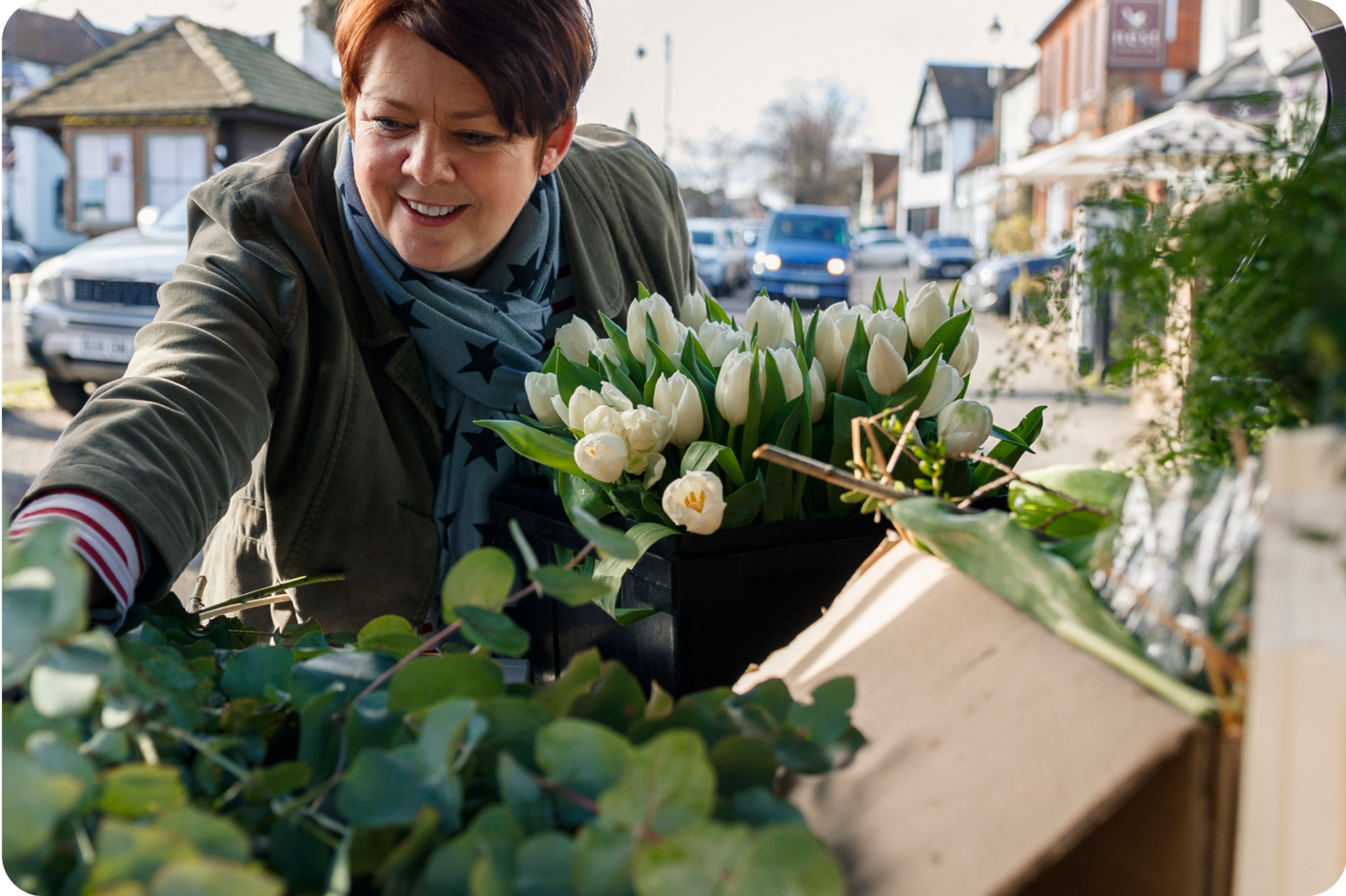 Smiling Zego business van customer taking flowers out of her van