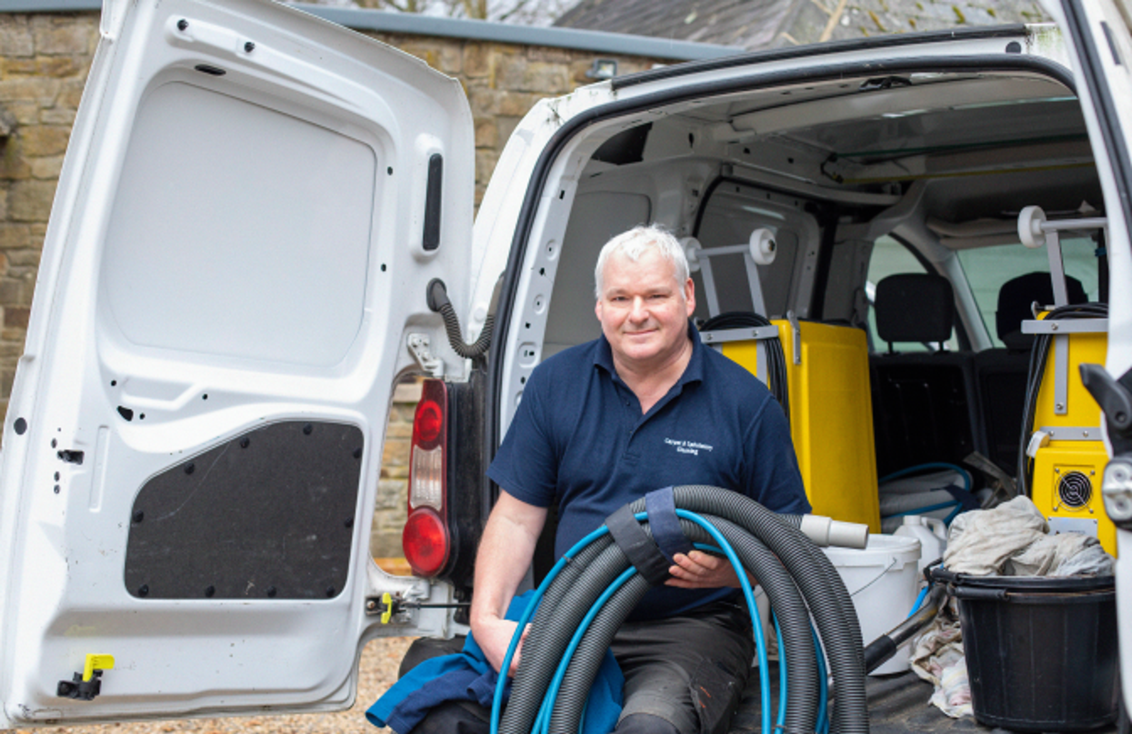 man holding pipes outside a white van.