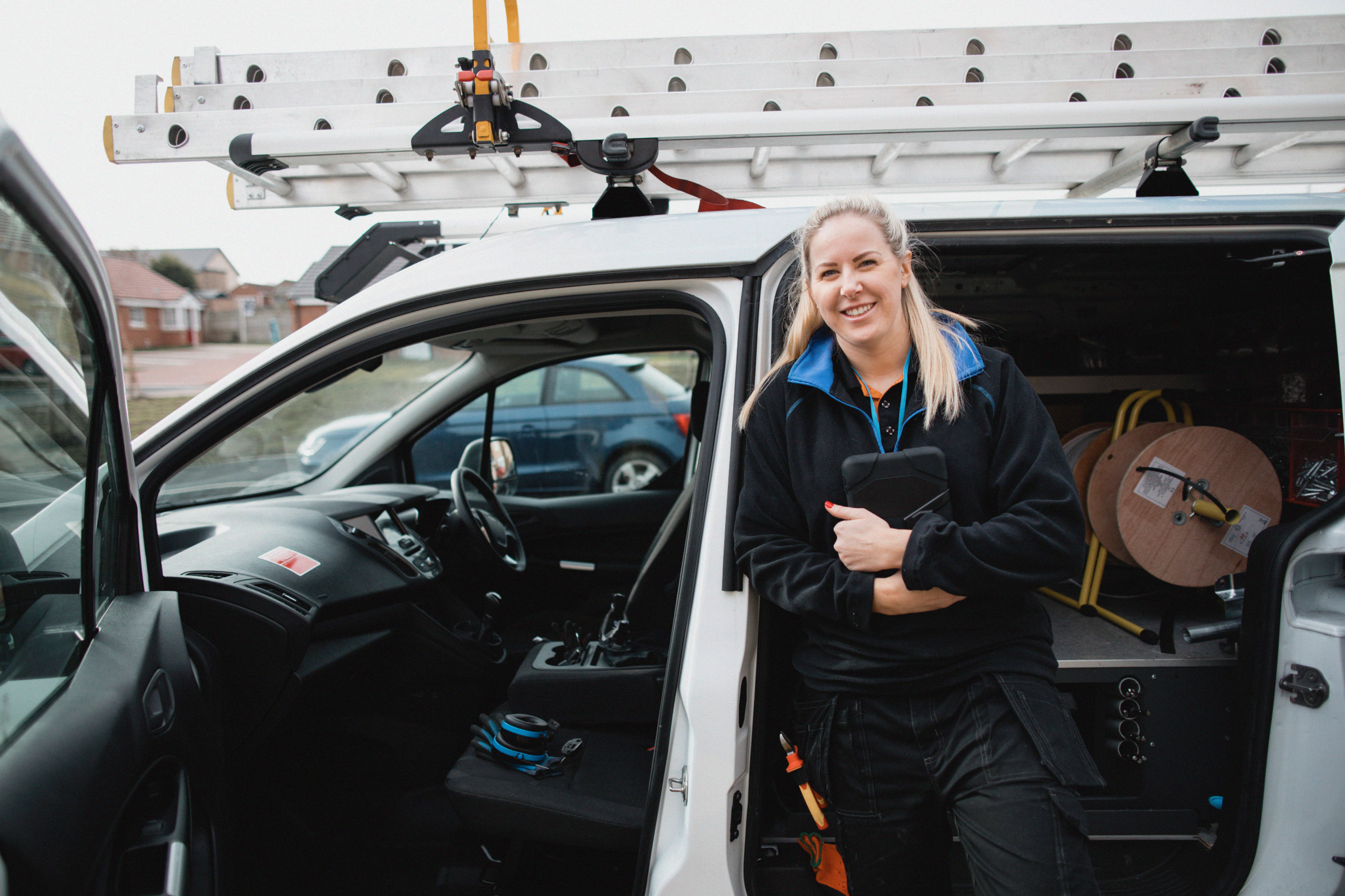 Van driver smiling outside parked white van