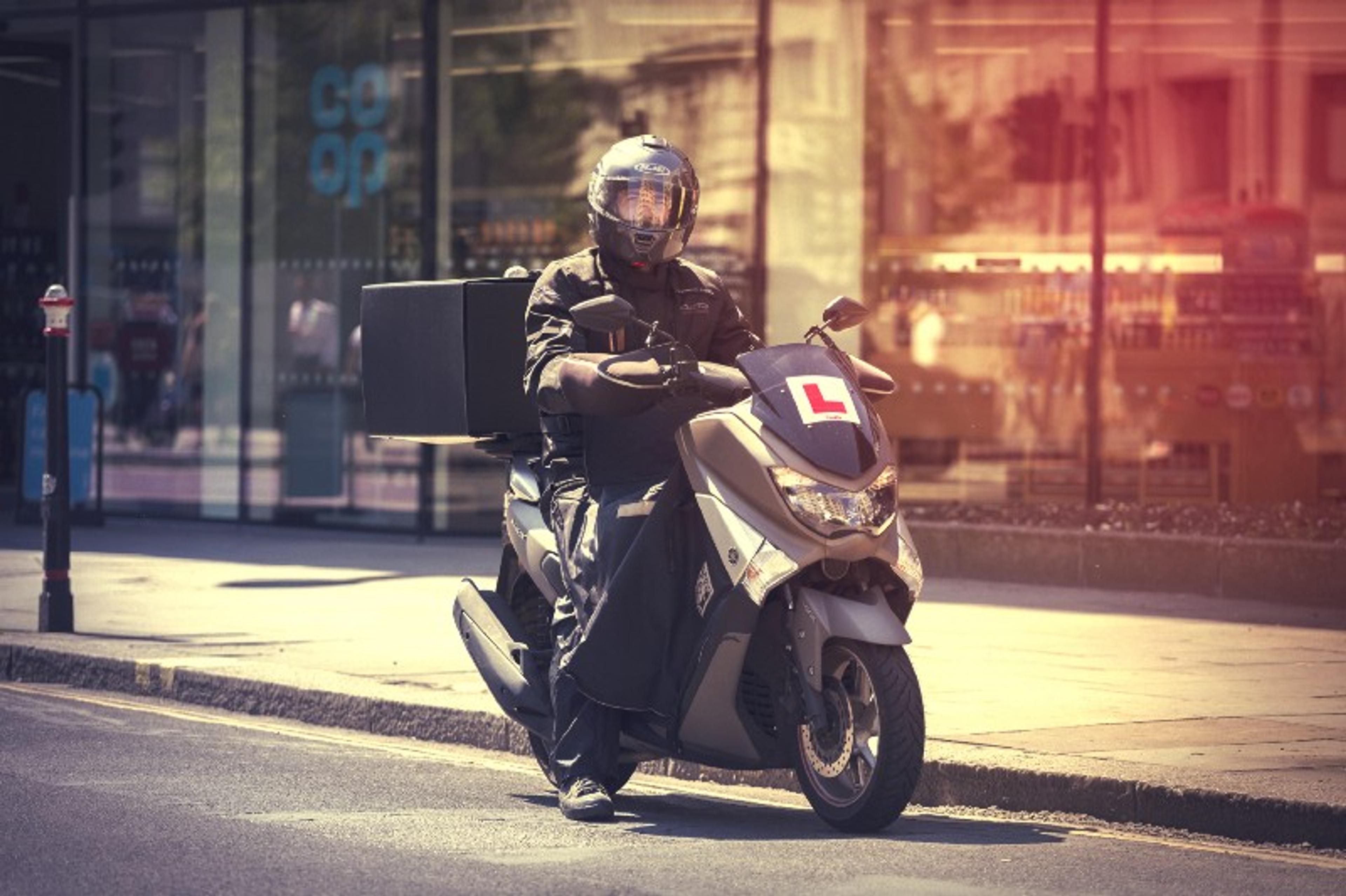 deliveroo scooter rider who is a learner delivering food outside of coop