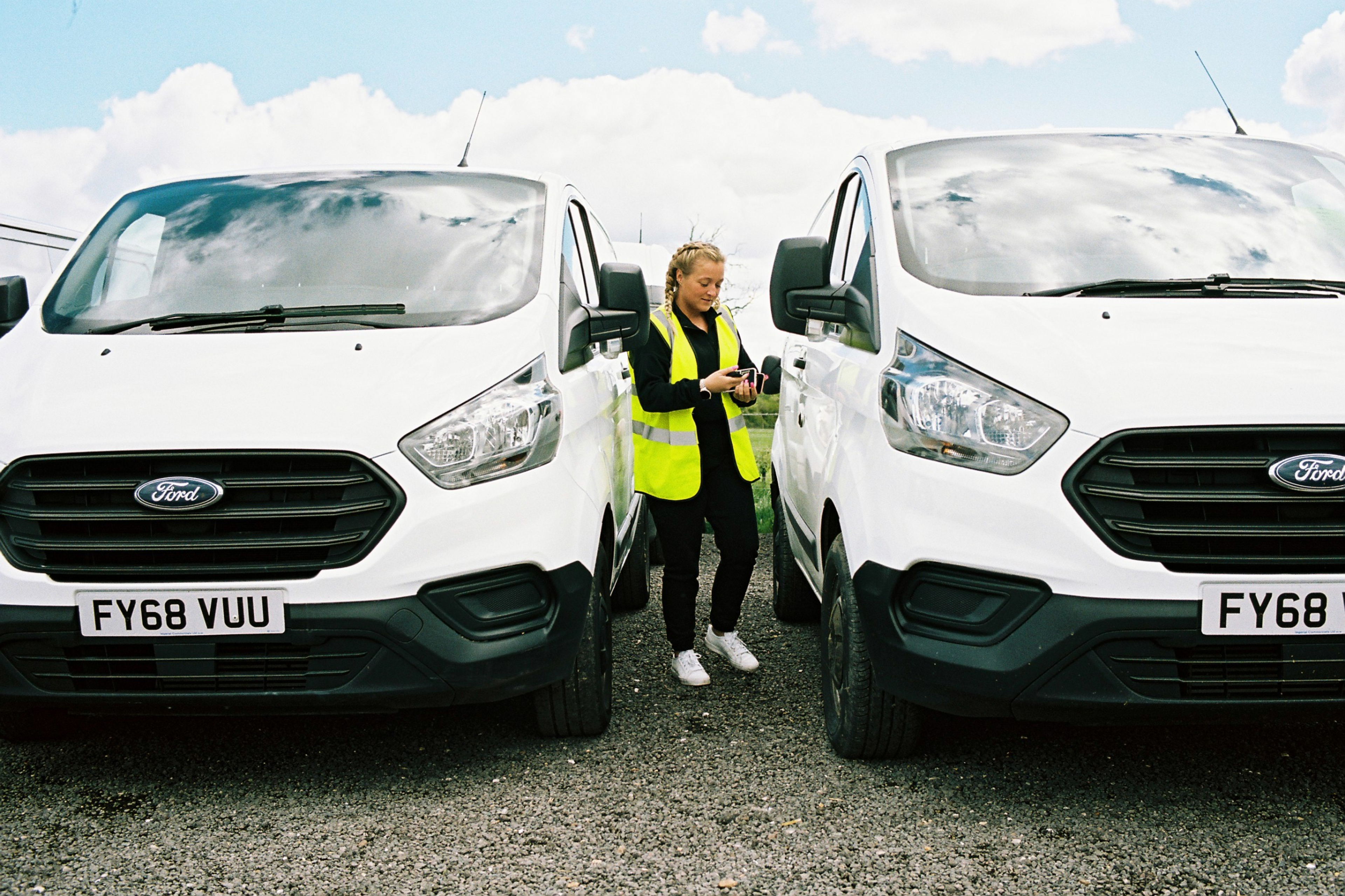 Van driver on her phone next to parked vans