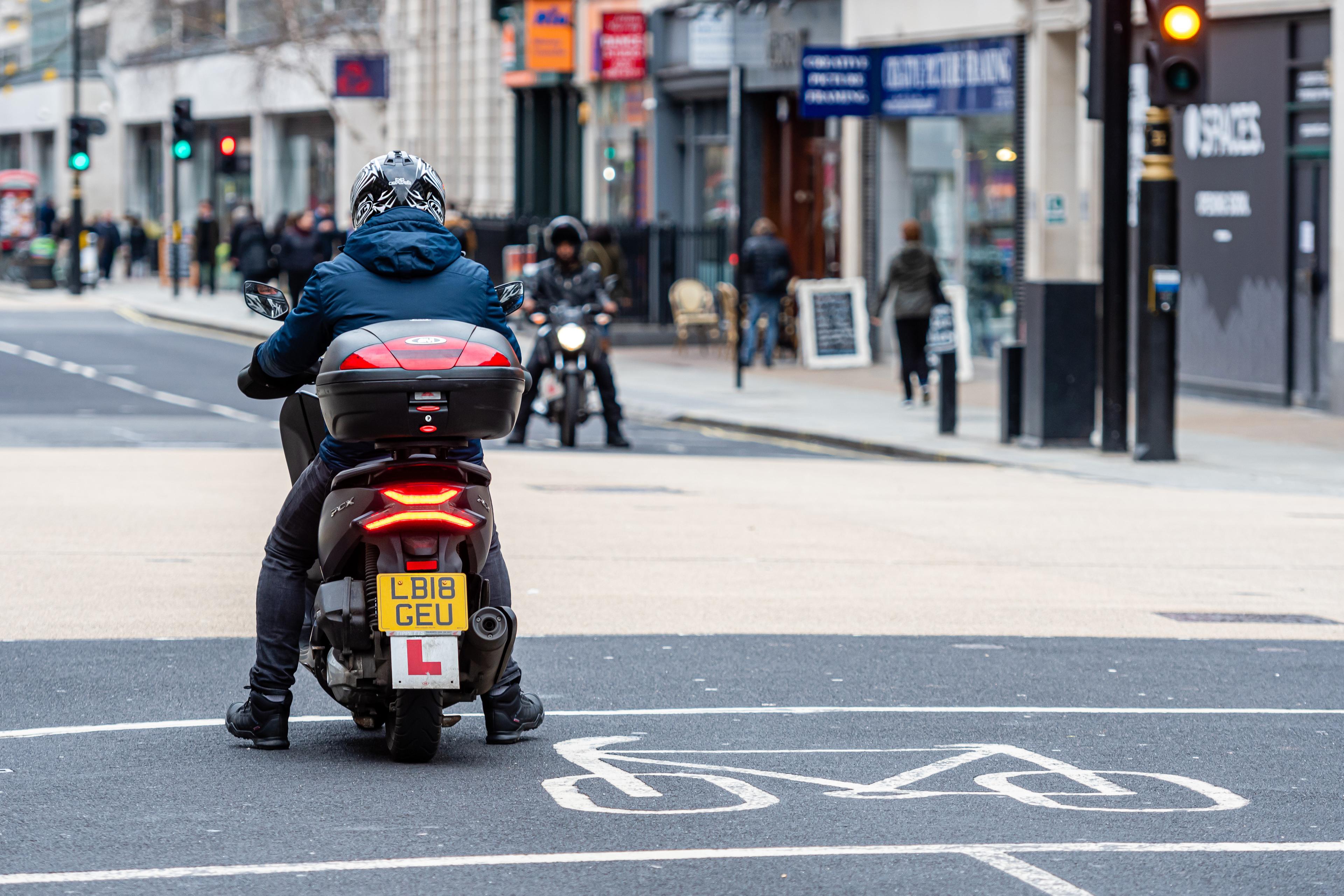 man delivering food on a learner scooter