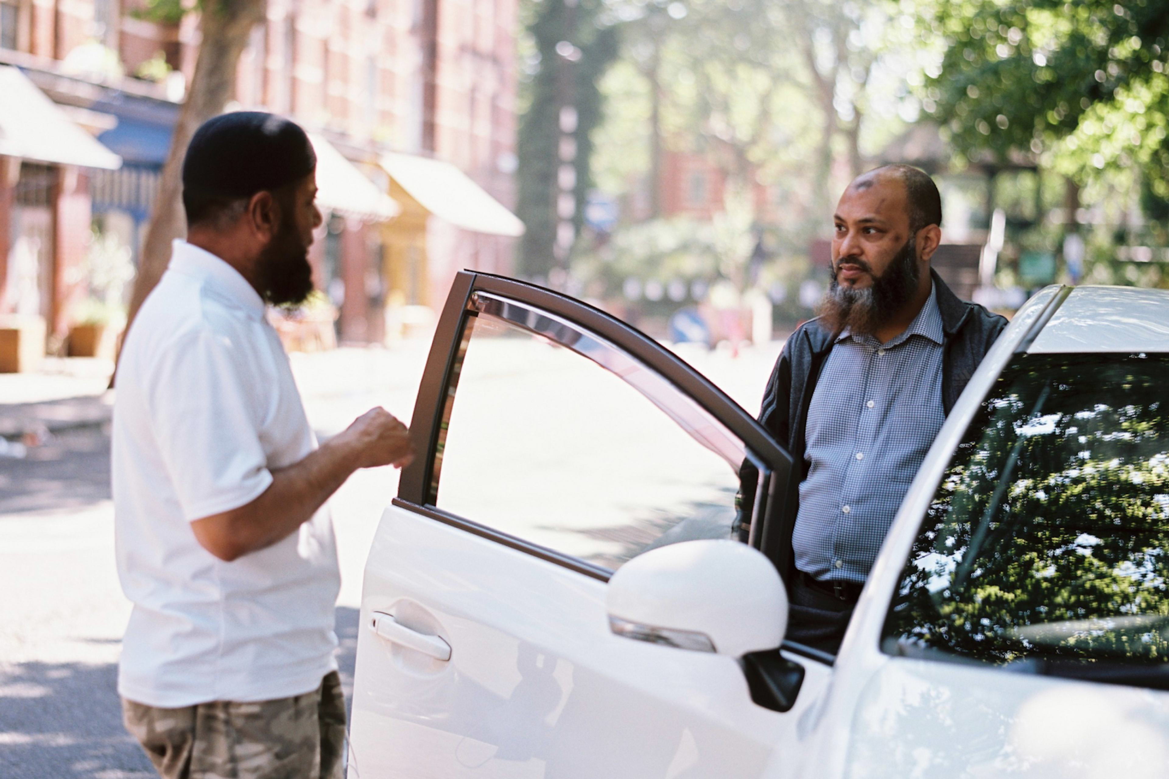 Two taxi drivers standing in front of a car
