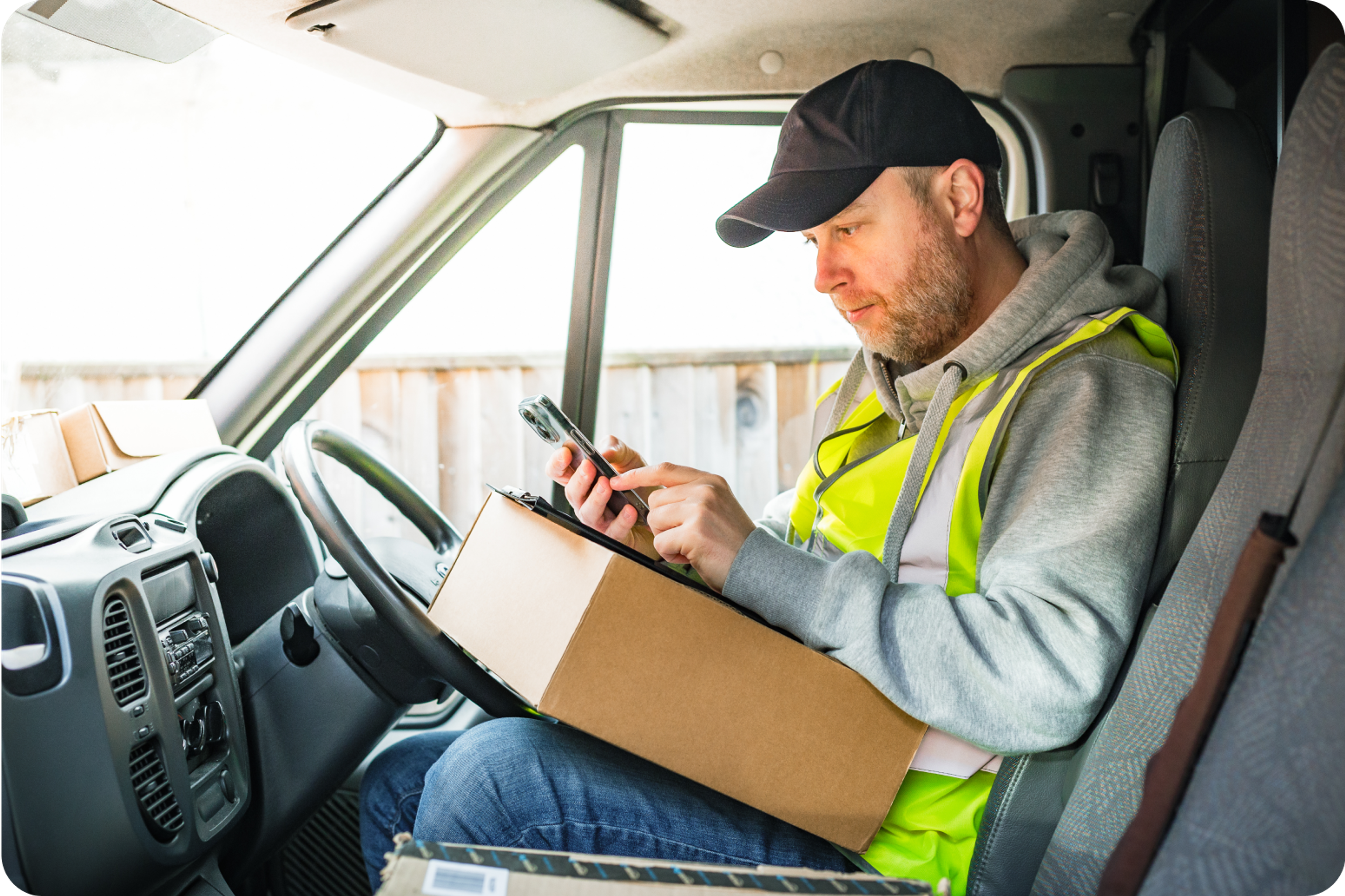 Zego courier van driver checking his Zego policy on his phone in his van