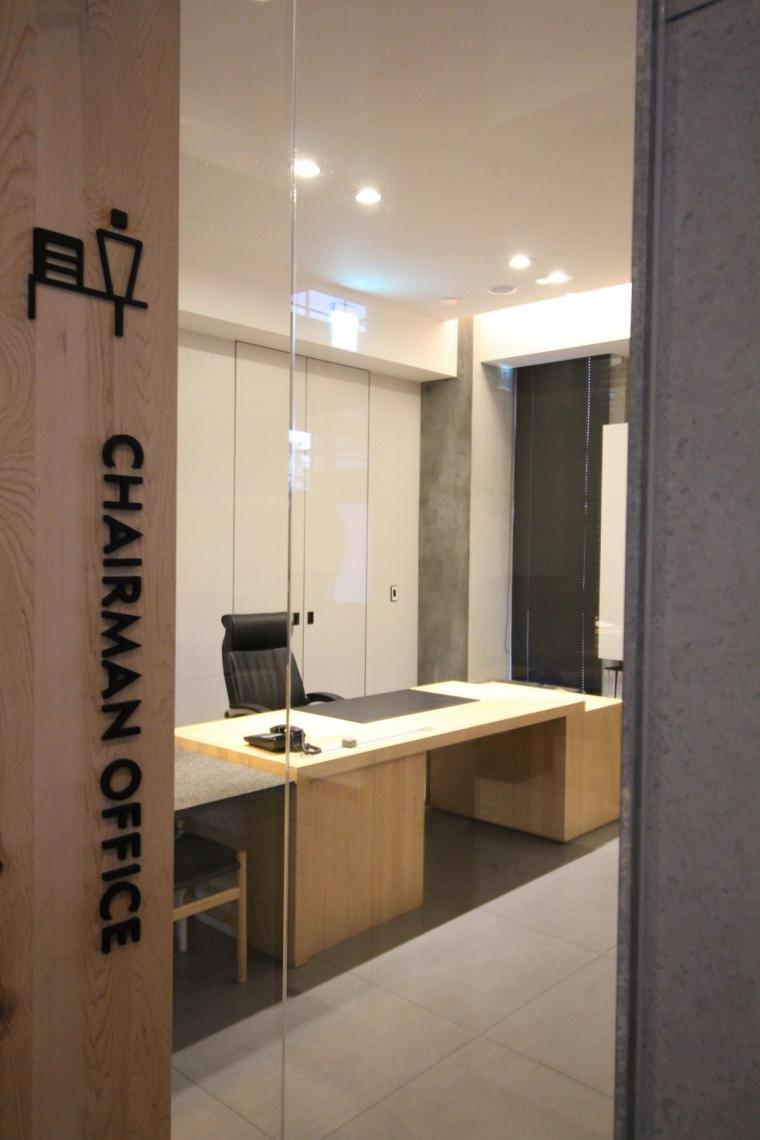 走廊一邊是品牌歷程的藝術展示、另一邊是董事長辦公室,動線設計得很有故事性。