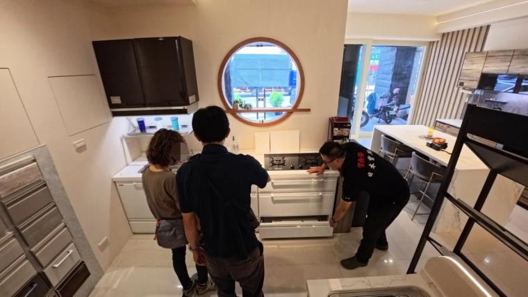 師傅到家一組組安裝——檯面定位、拆箱、接水電,白色琺瑯櫃體現場顧得很仔細。
