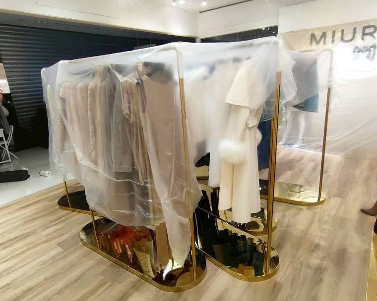 我妹一個人顧的服飾店——師傅一進場就先用塑膠布把商品、櫃檯層層蓋好，防塵保護做得很細。