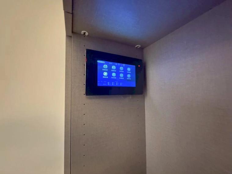 玄關那座雙功能櫃，正面電視牆、背面鞋櫃一物兩用；牆上還嵌了智能控制面板，小宅也很有科技感。