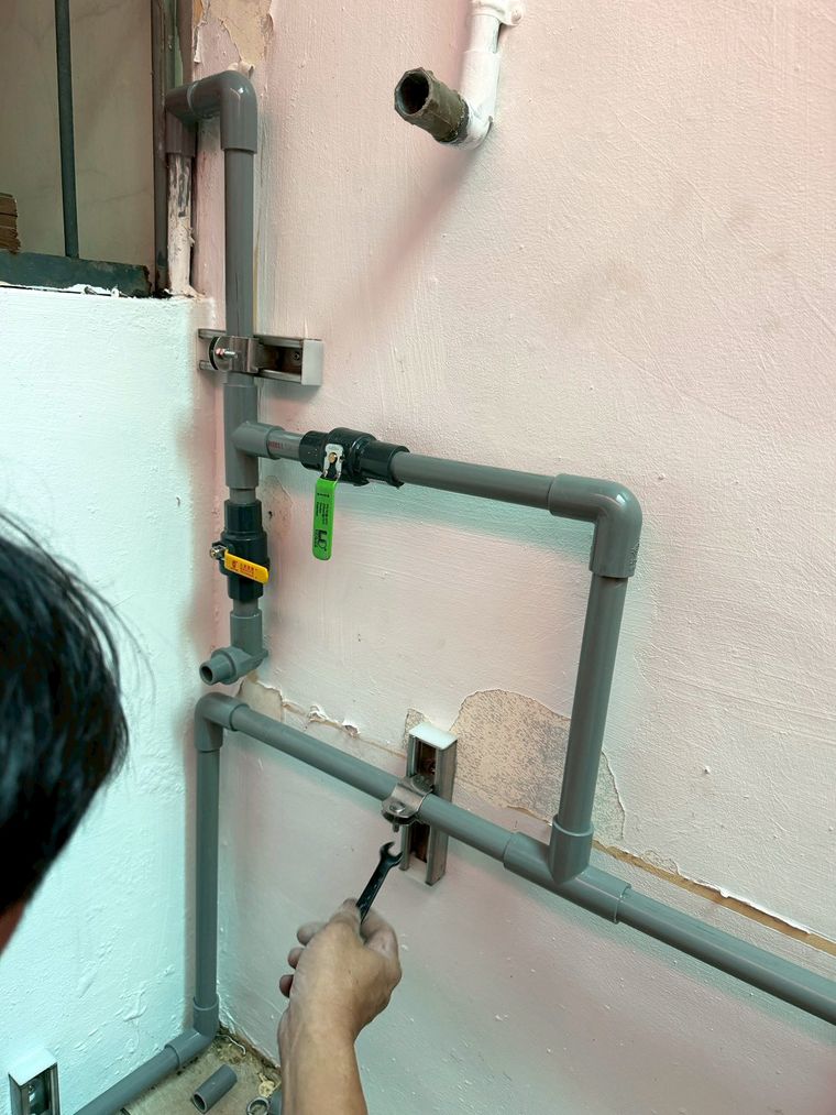 師傅把設備安排在原本閒置的空間,牽管、接頭、用水平儀一一量過——管路藏得整齊,位置也抓得準。