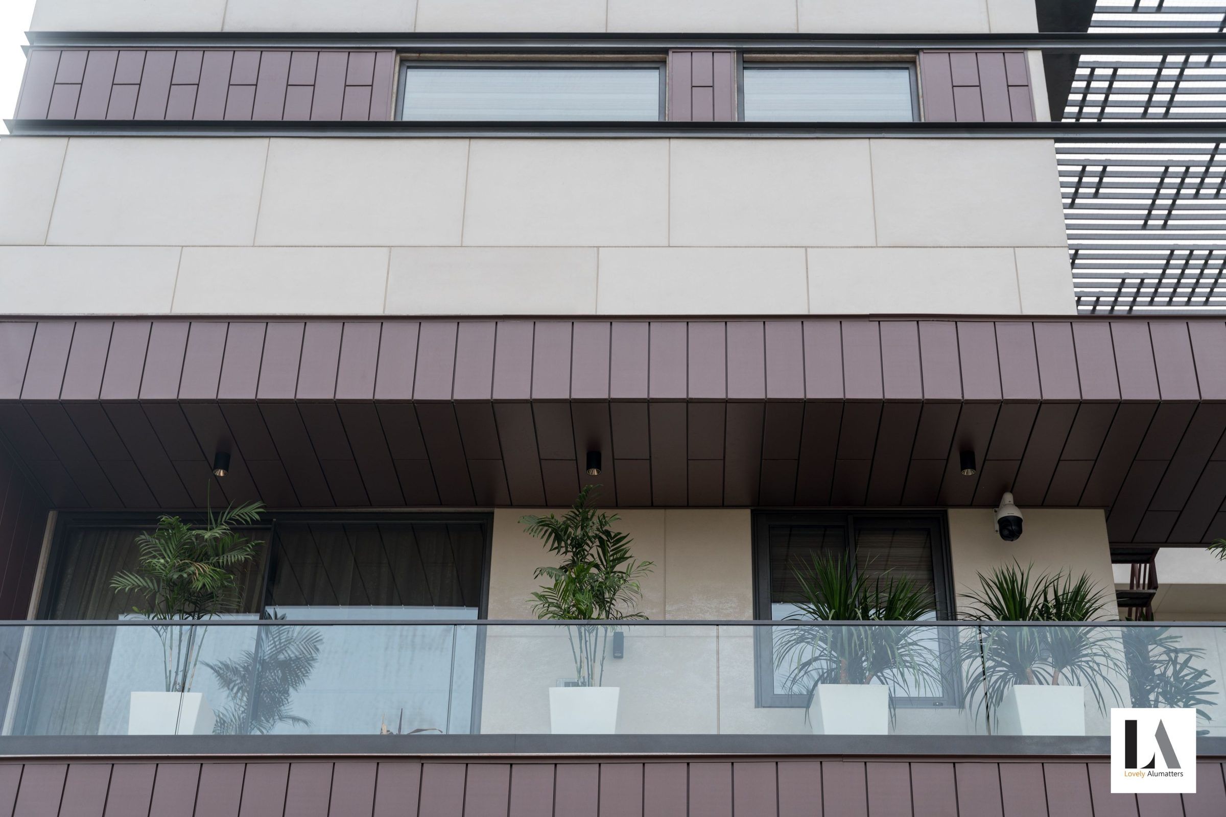 Façade detail with large windows behind a glass balustrade