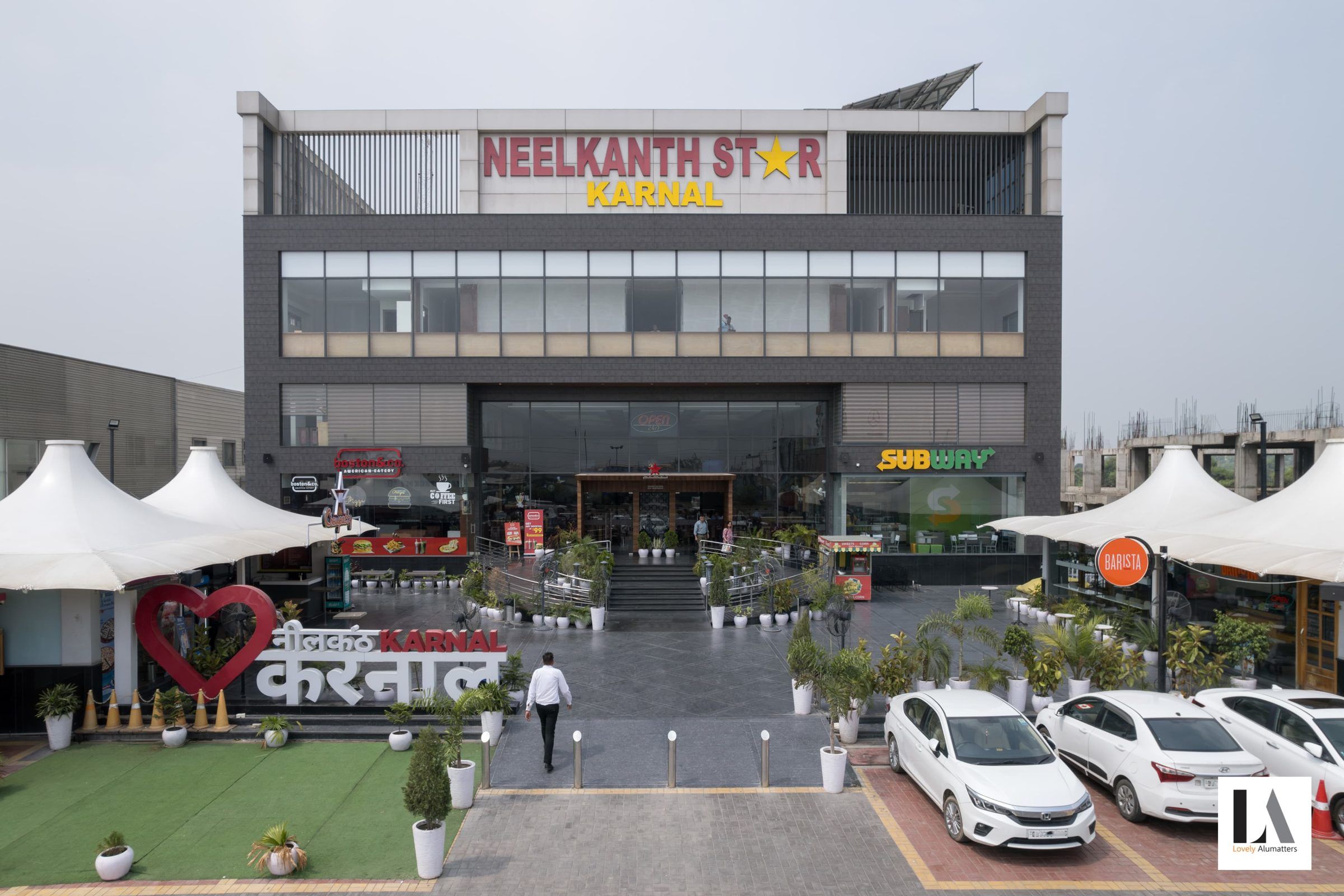 Glazed façade of a hospitality building above landscaped seating