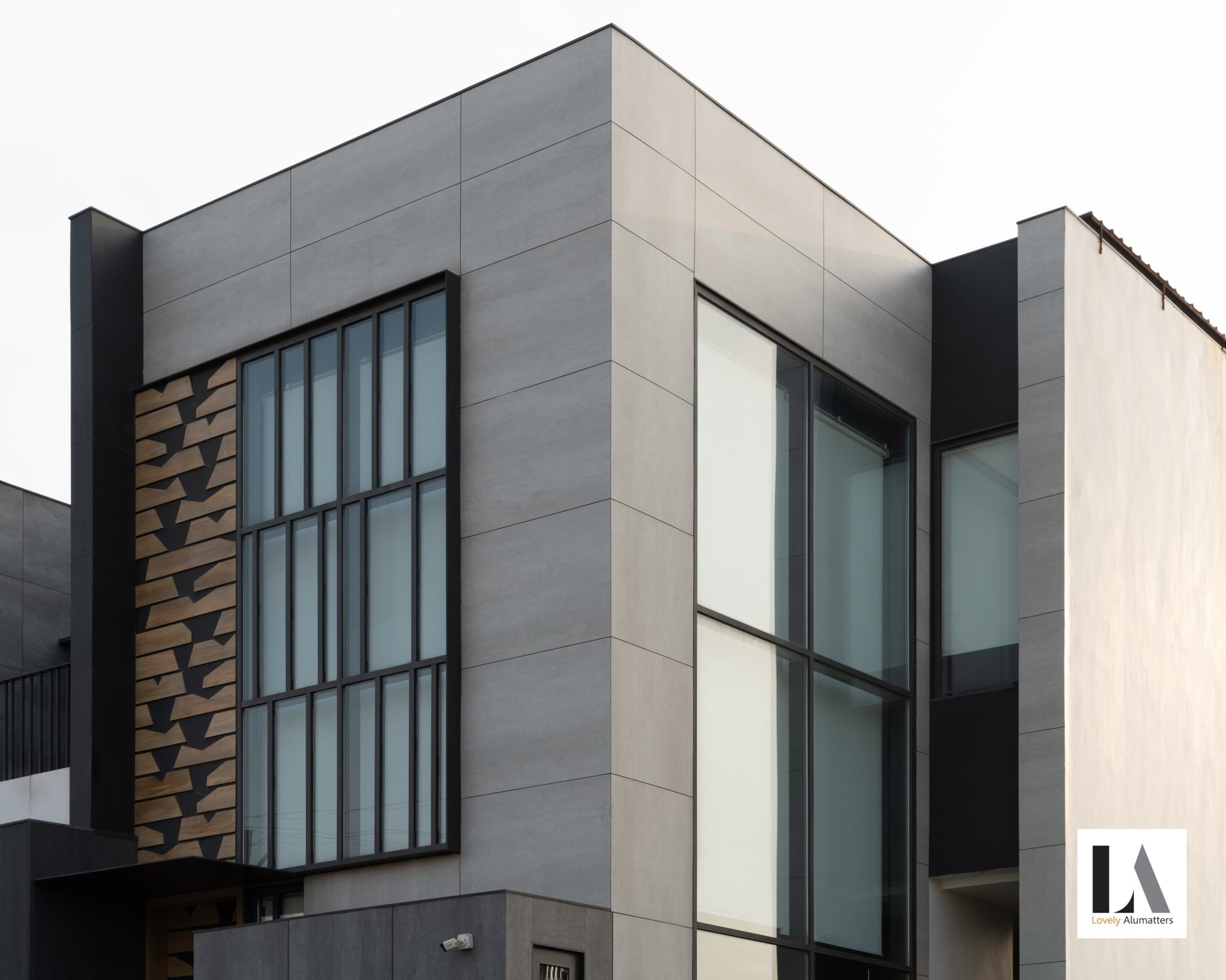 Grey-tiled façade with tall gridded windows and a full-height glazed corner