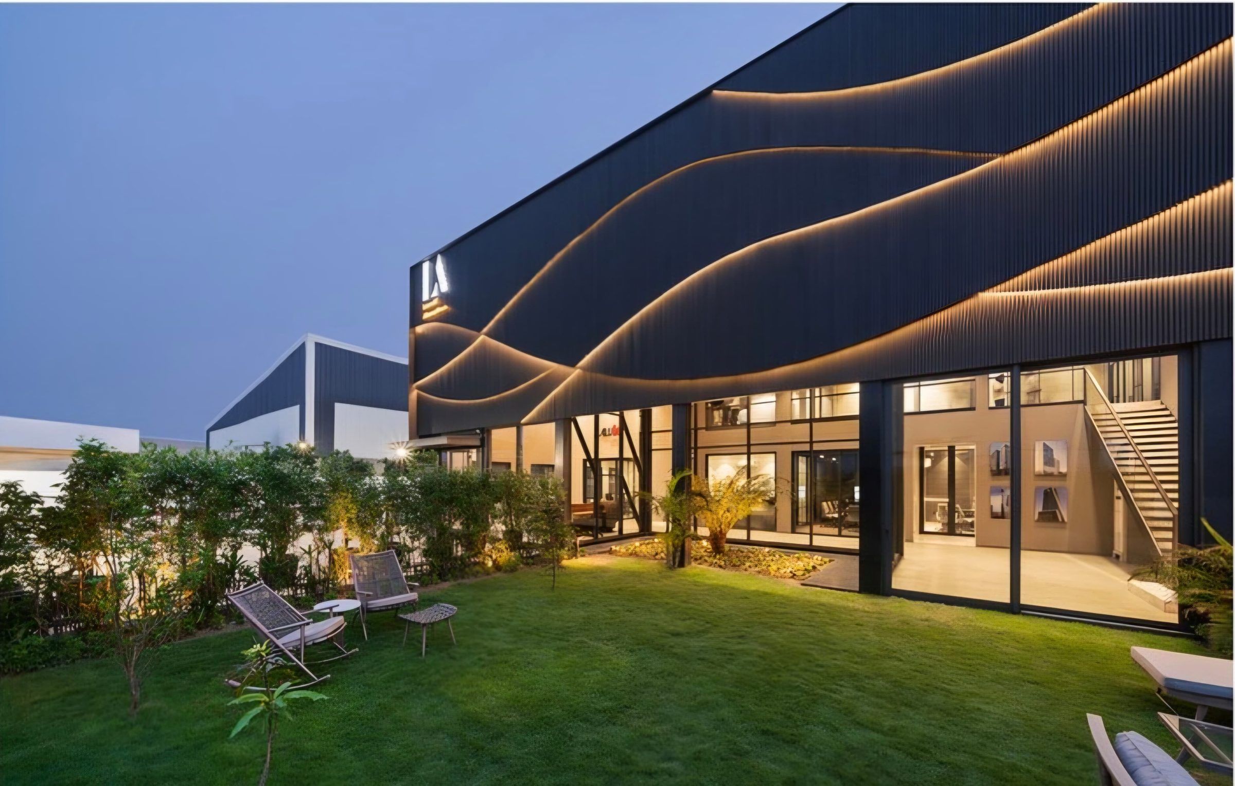 Facility frontage and lawn at dusk with full-height glazing
