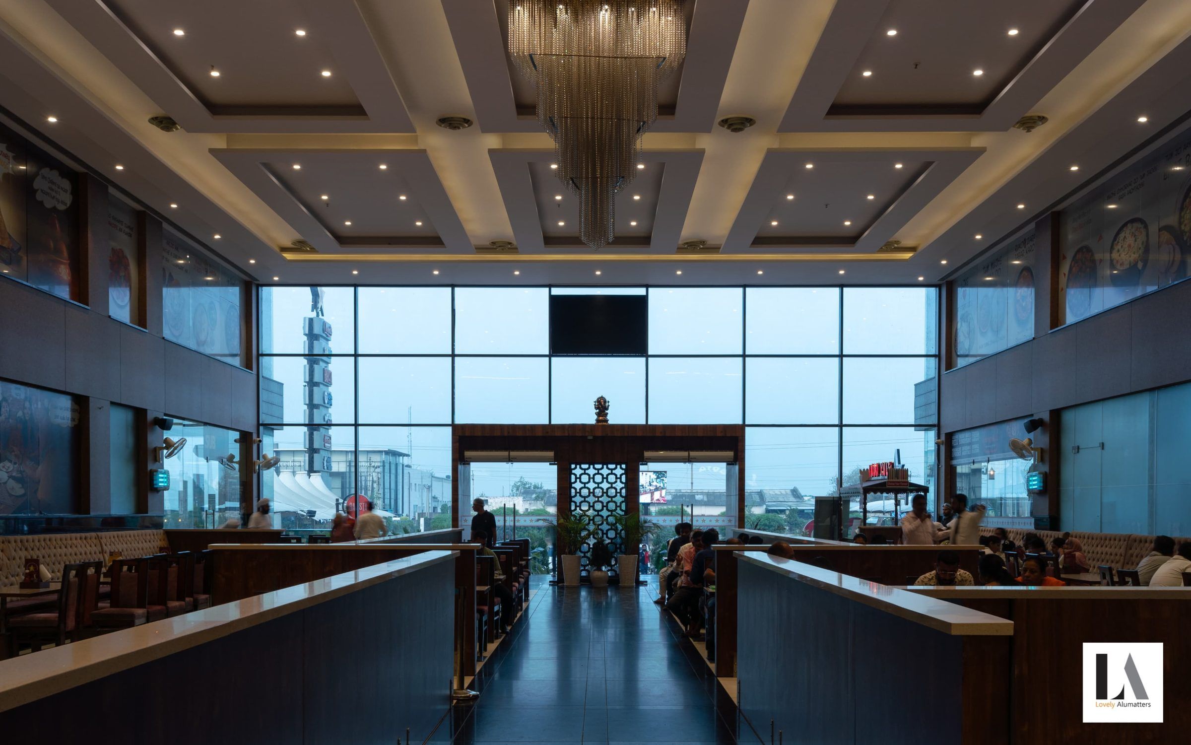 Restaurant interior opening to a full-height glazed wall