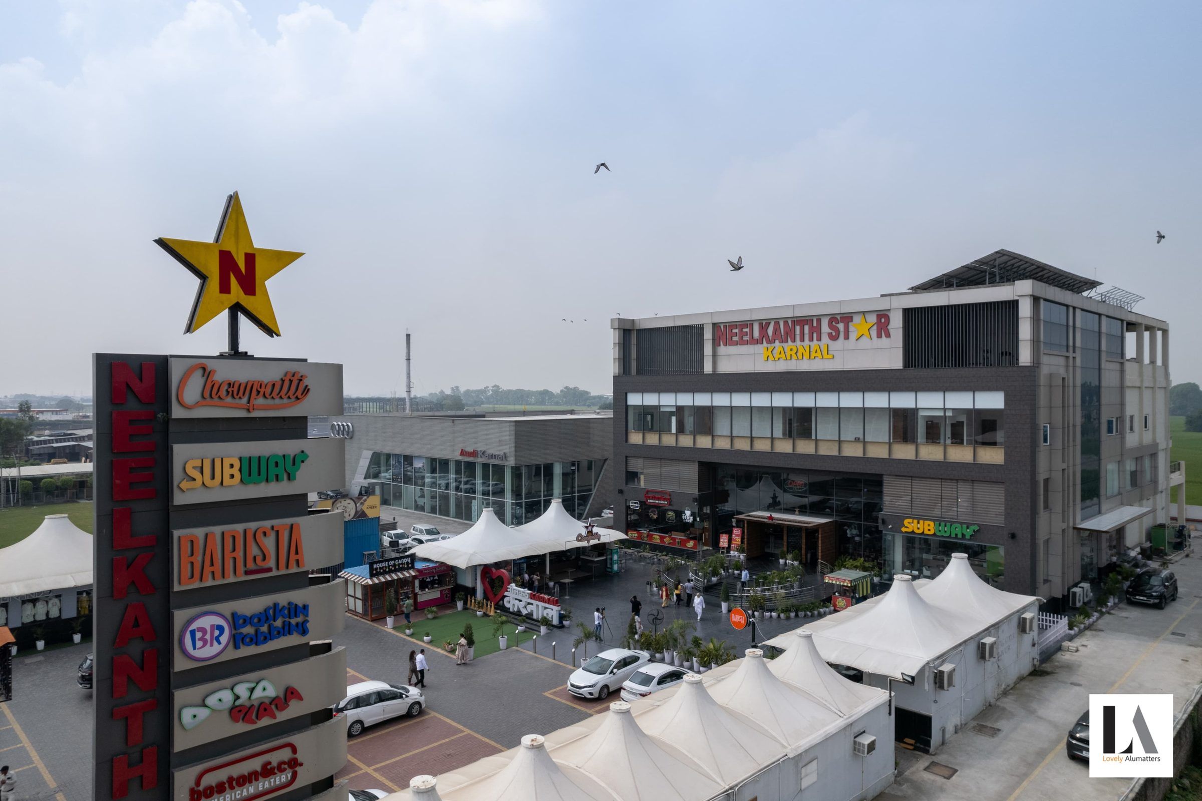 Hospitality complex with glazed upper floors beside the forecourt